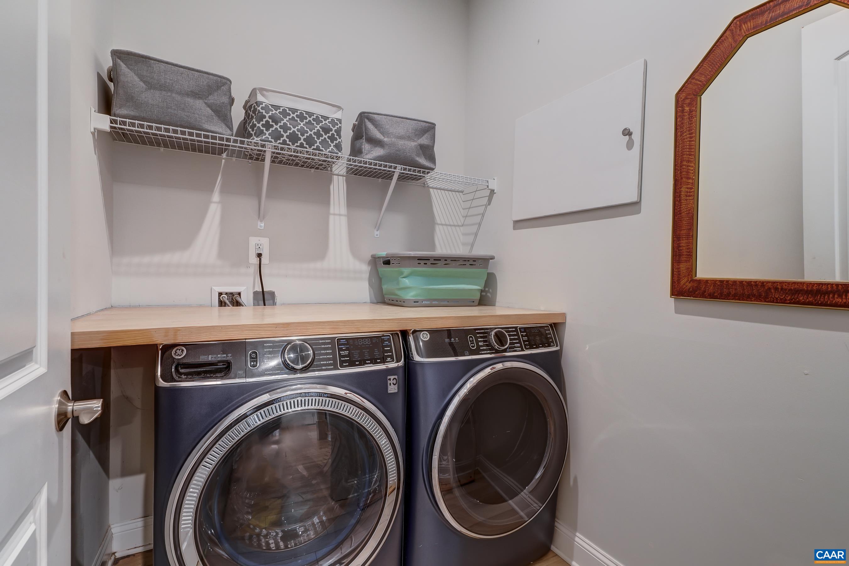 Laundry room with folding/storage shelf above washer and dryer.