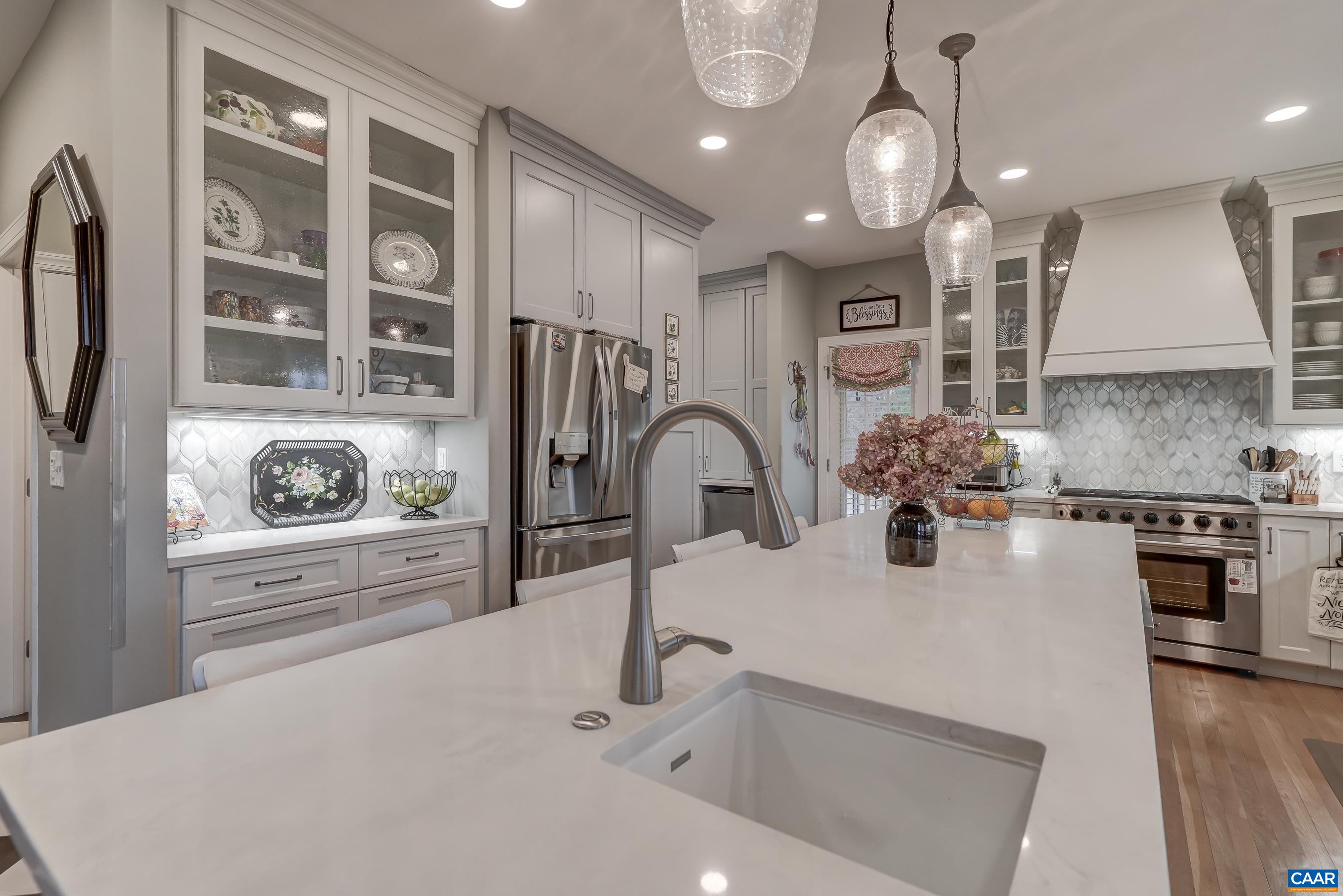 Beautiful kitchen features two-tone cabinetry and quartz countertops. Expansive island with prep sink. Beautiful kitchen features two-tone cabinetry and quartz countertops. Expansive island with prep sink.