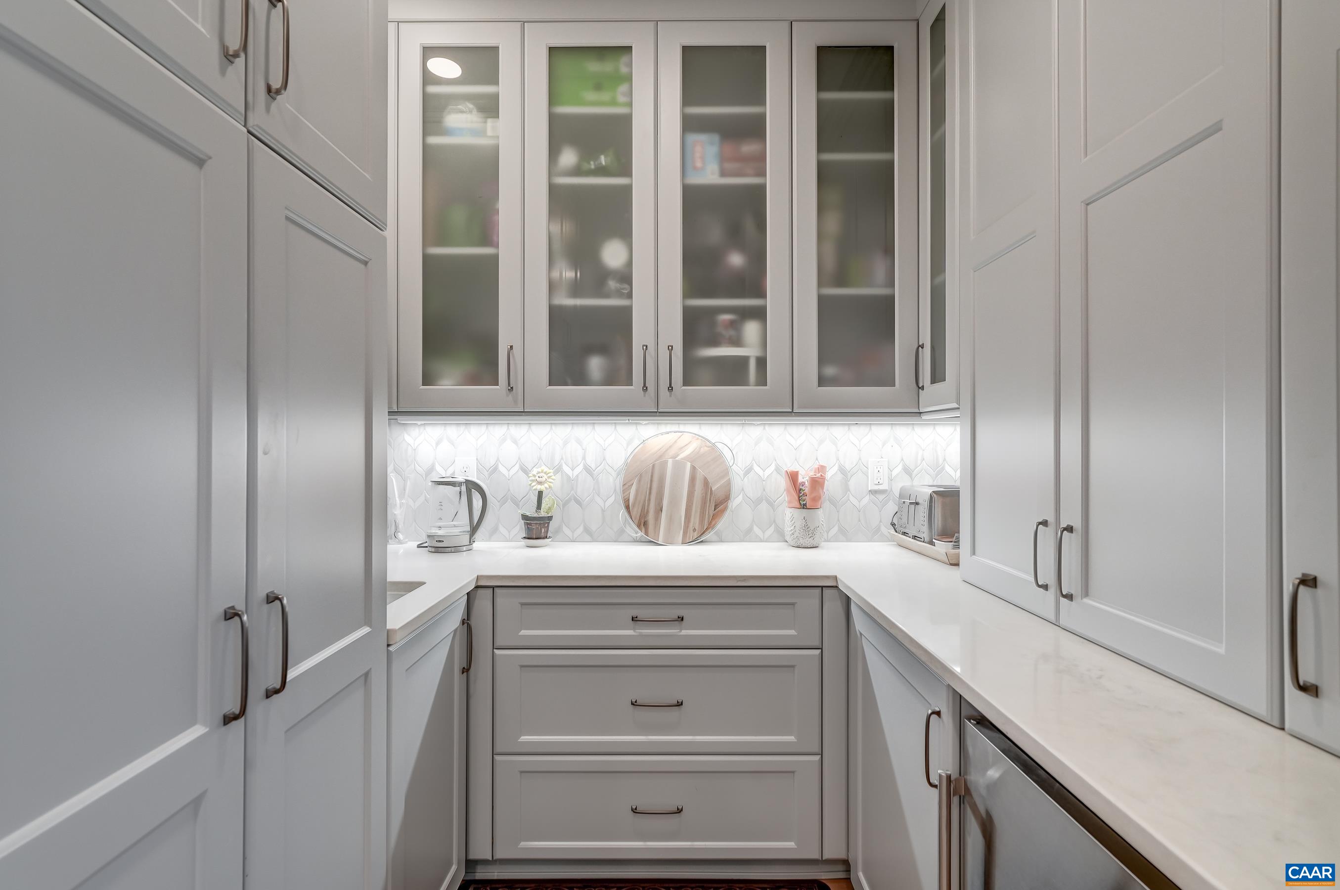 Walk in pantry with glass front cabinets, and extra prep sink. Walk in pantry with glass front cabinets, and extra prep sink.
