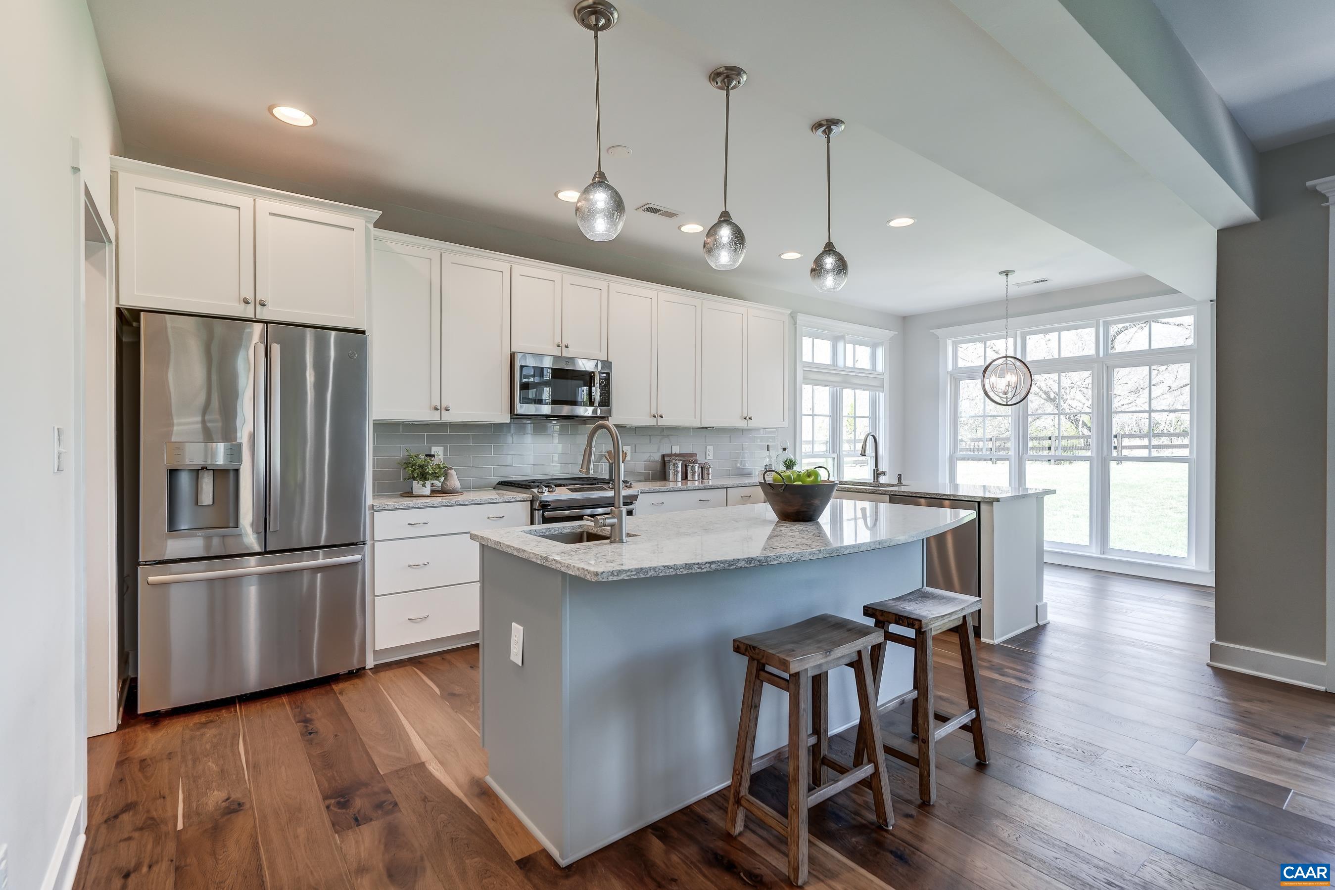 Gourmet kitchen with granite counters, white cabinets, and stainless appliances.