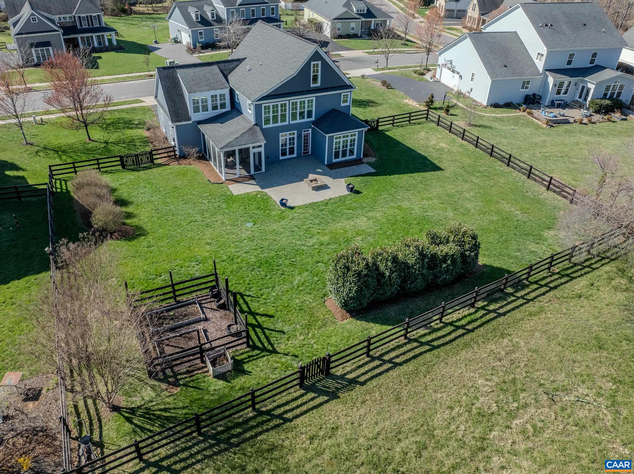 Fenced back yard with gardens, patio with firepit and great screened porch!