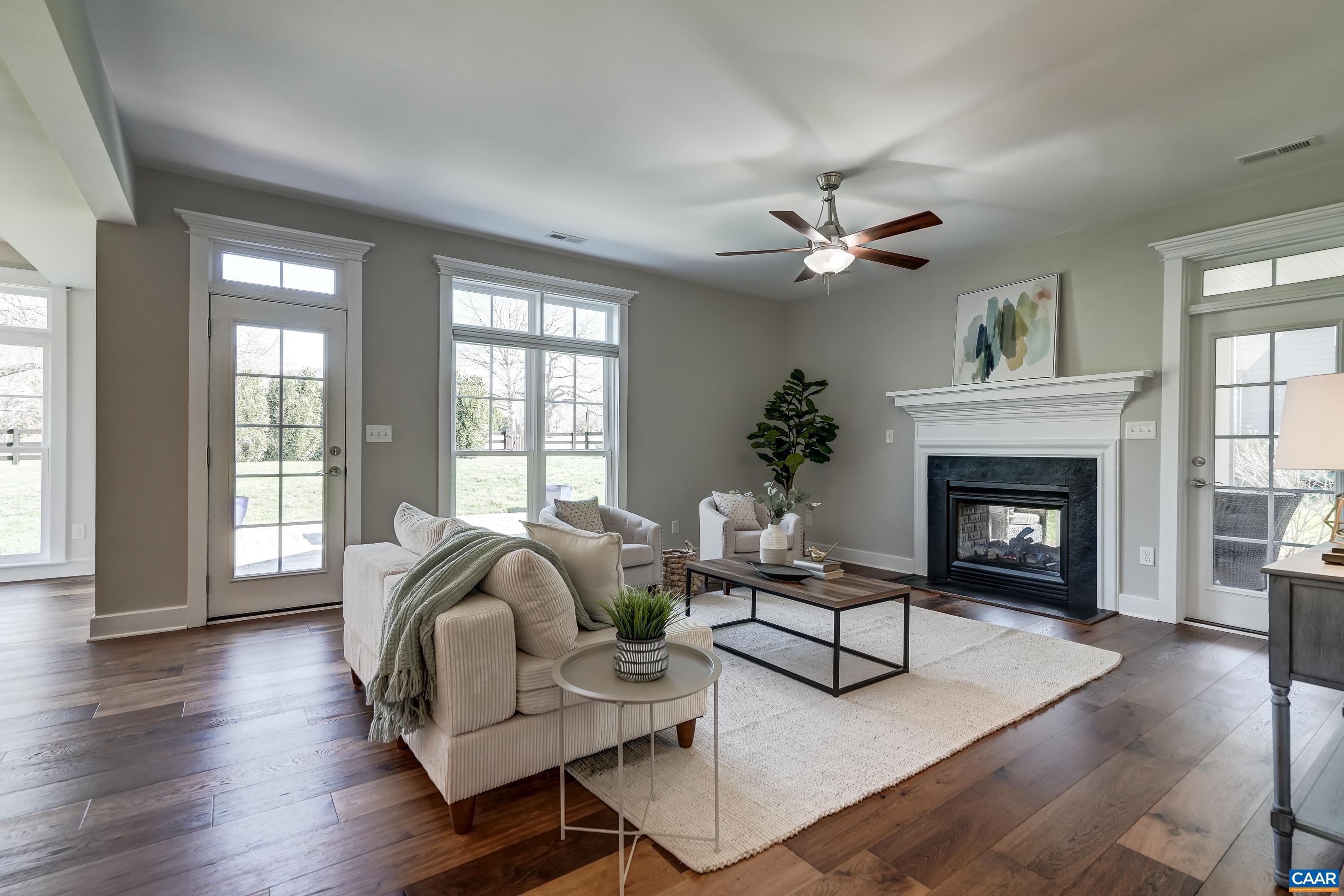 Great room with fan and dual sided gas fireplace.
