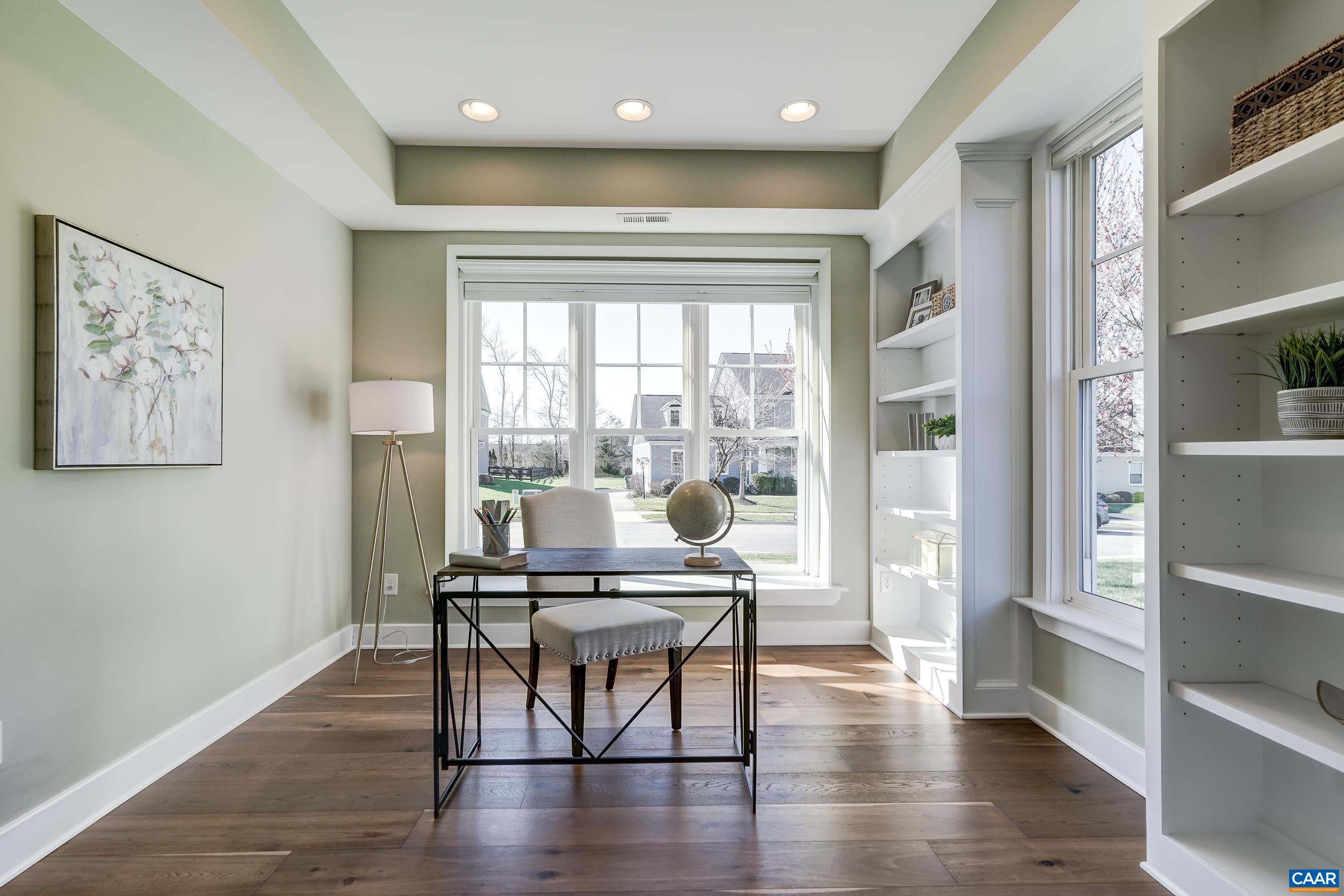 Home office with sliding pocket doors and built-in shelving.
