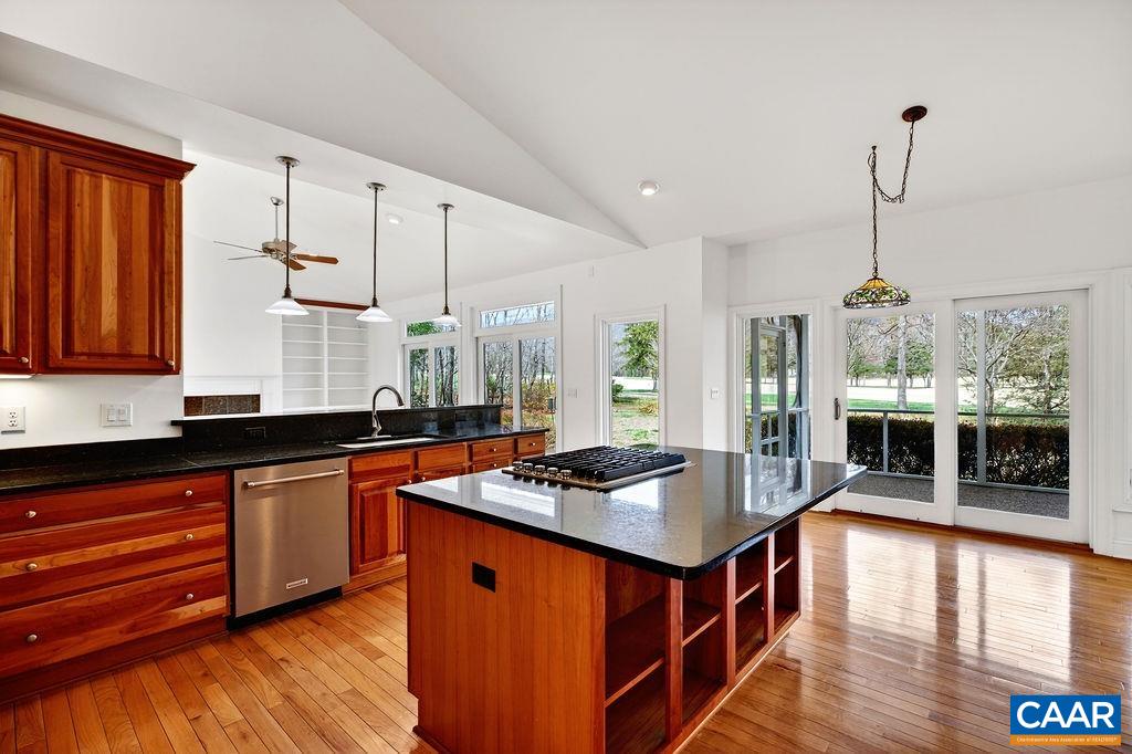 The spacious kitchen features granite countertops, cherry cabinetry, a gas cooktop, double wall oven, and a pantry.