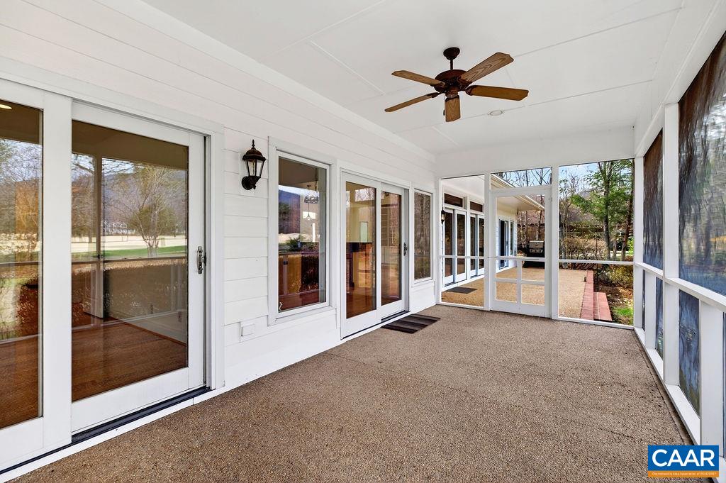 Spacious screened porch offering stunning mountain and golf fairway views—perfect for relaxing or entertaining in a peaceful, scenic setting.