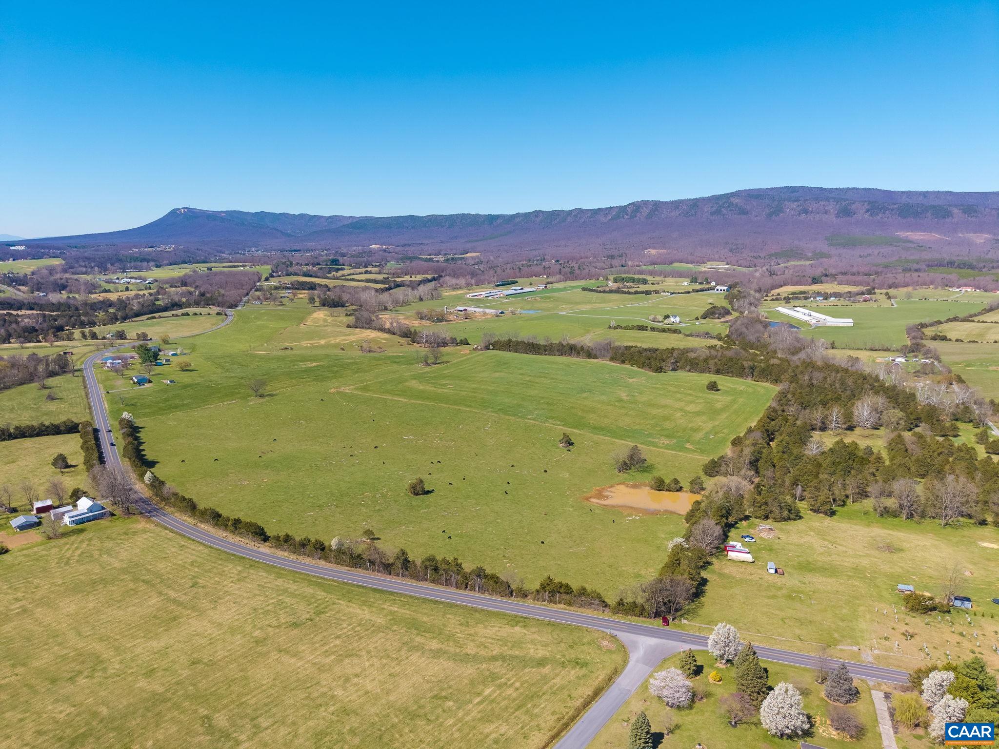 Beautiful mountain views from this mostly open parcel of land.  The pond is in view, and the stream is in the forested area that runs left to right across the back 1/3 of the parcel.