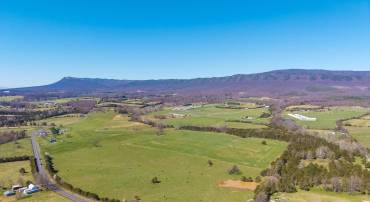 Beautiful mountain views from this mostly open parcel of land.  The pond is in view, and the stream is in the forested area that runs left to right across the back 1/3 of the parcel.