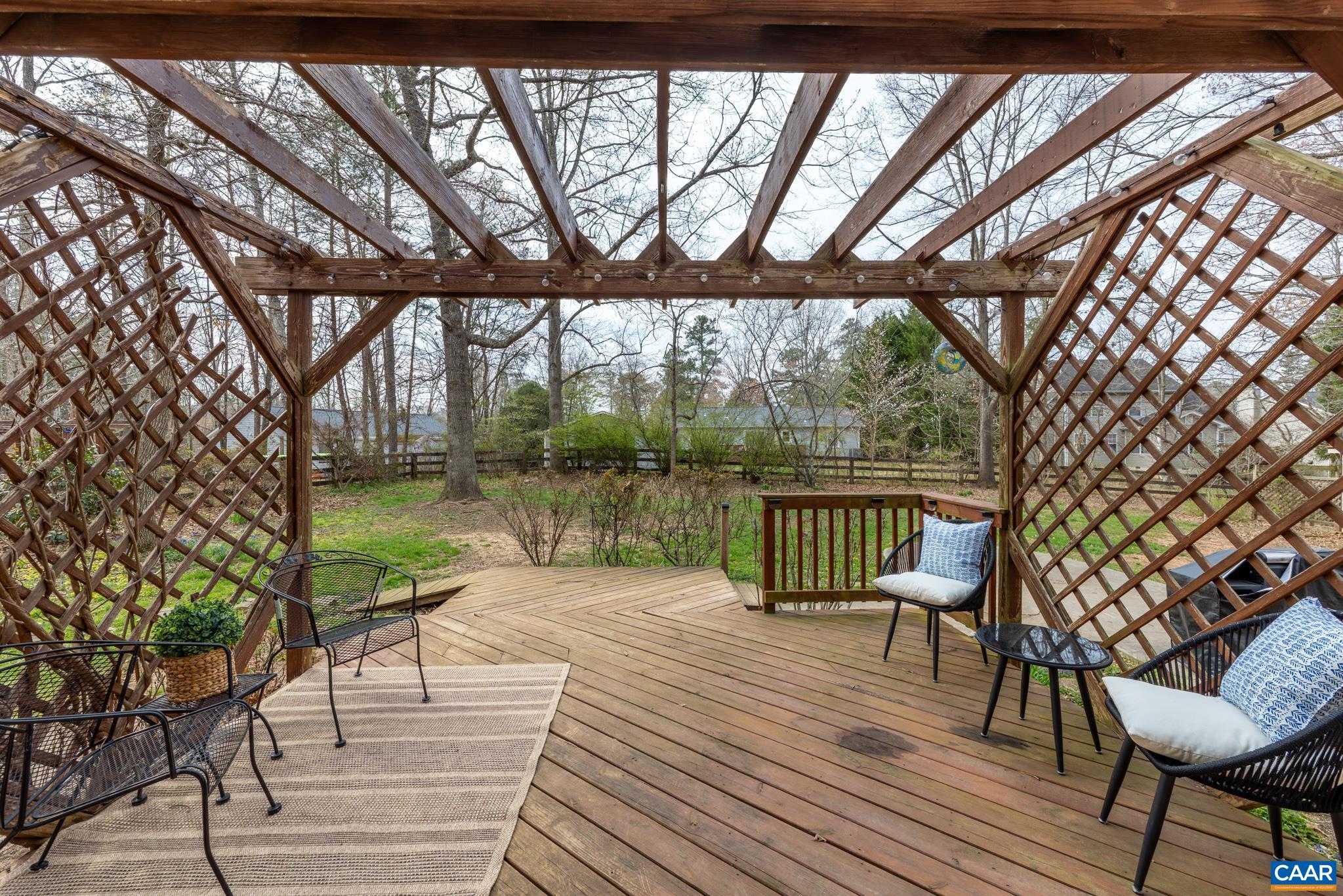 Outdoor living suite including both a raised deck with pergola and a lower-level concrete patio for versatile entertaining Outdoor living suite including both a raised deck with pergola and a lower-level concrete patio for versatile entertaining