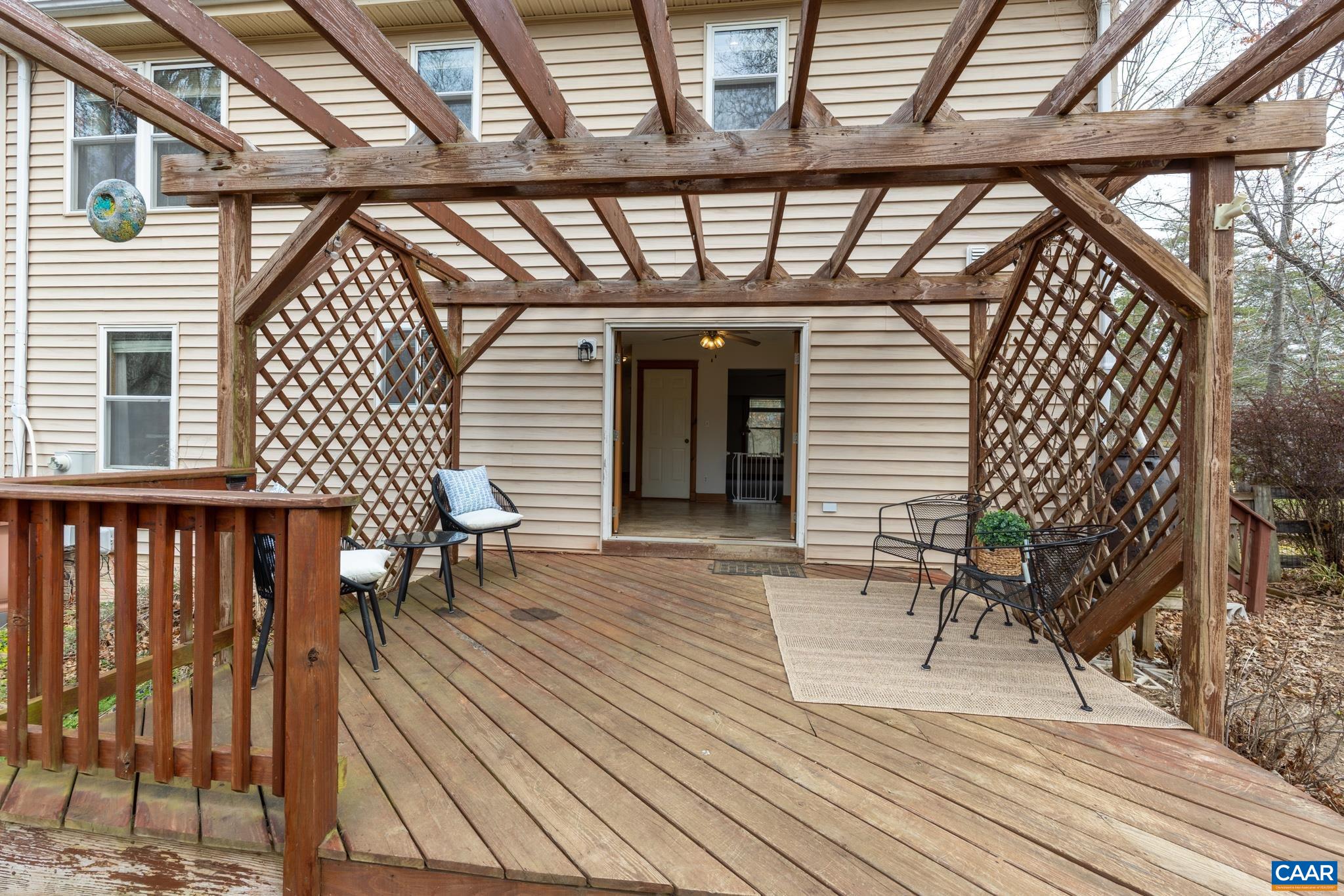 Expansive rear deck featuring a custom pergola cover, perfect for shaded outdoor dining and relaxation. Expansive rear deck featuring a custom pergola cover, perfect for shaded outdoor dining and relaxation.