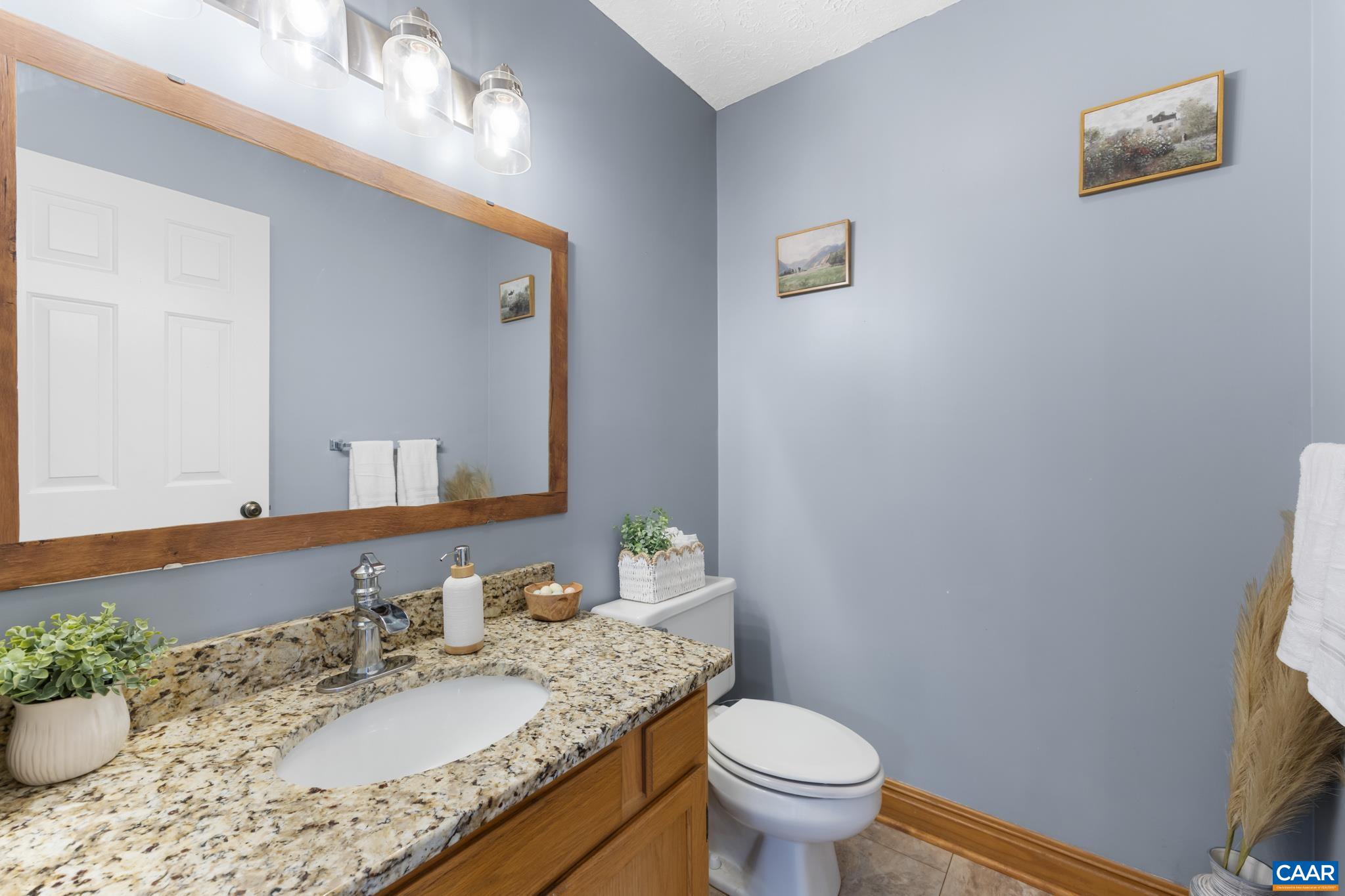 Main-floor powder room/half bath located near the foyer and laundry area. Main-floor powder room/half bath located near the foyer and laundry area.