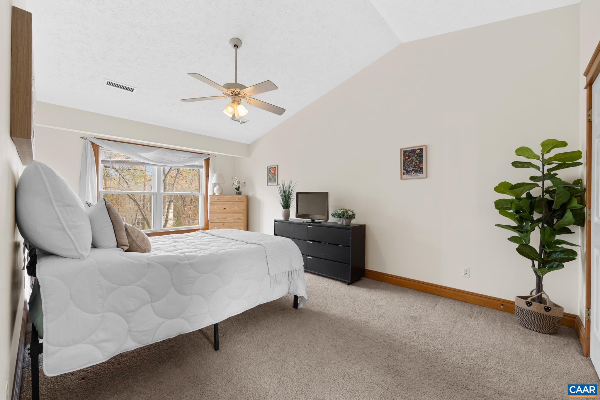 Second-floor primary suite boasting vaulted/cathedral ceilings and a spacious walk-in closet Second-floor primary suite boasting vaulted/cathedral ceilings and a spacious walk-in closet
