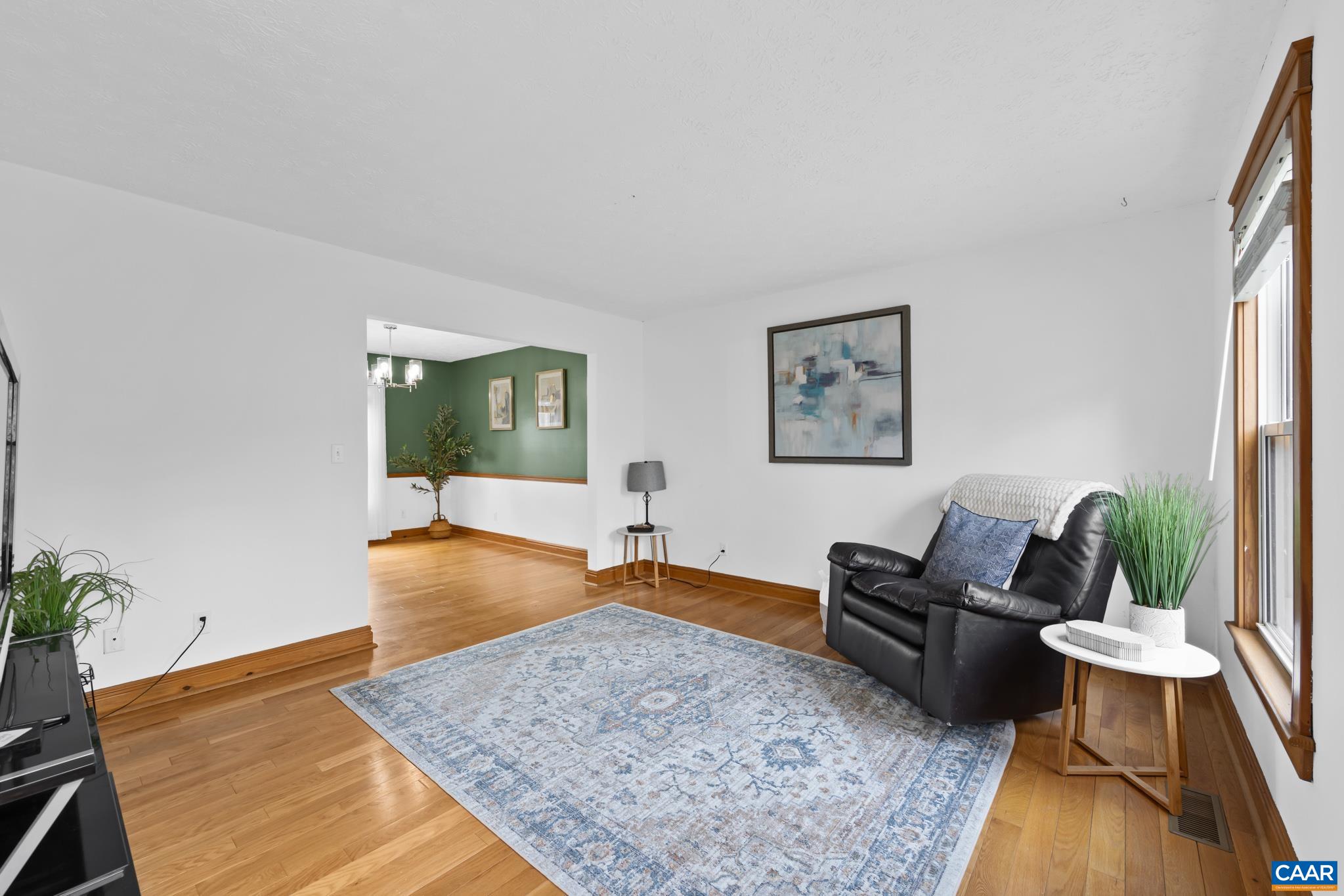 Bright and spacious living room featuring hardwood flooring and fresh interior paint Bright and spacious living room featuring hardwood flooring and fresh interior paint