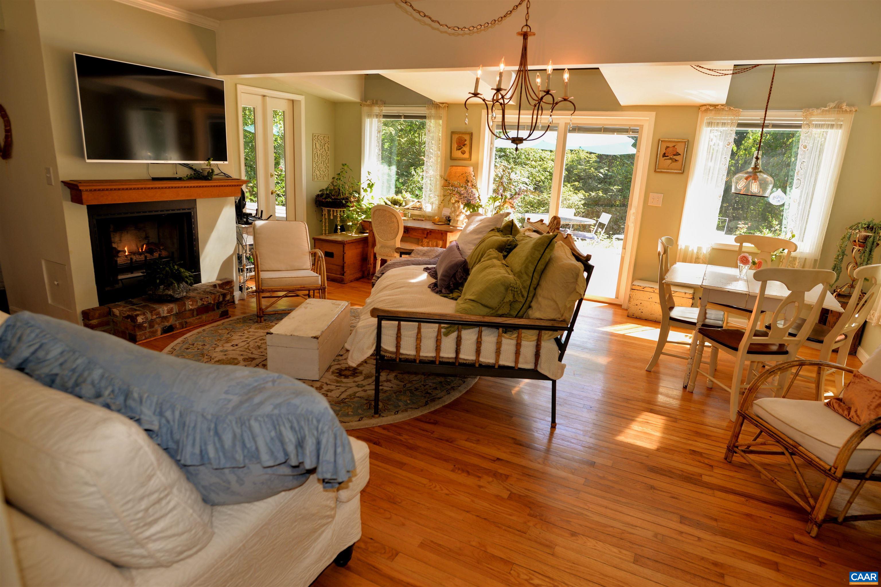 Living room with wood burning fireplace, and amazingly mellowed original hardwood flooring.