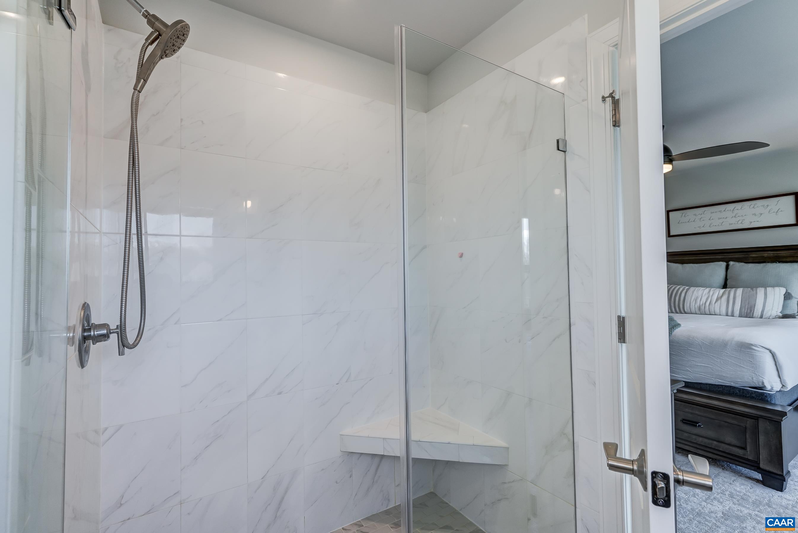 Frameless glass walk-in shower with spray wand.