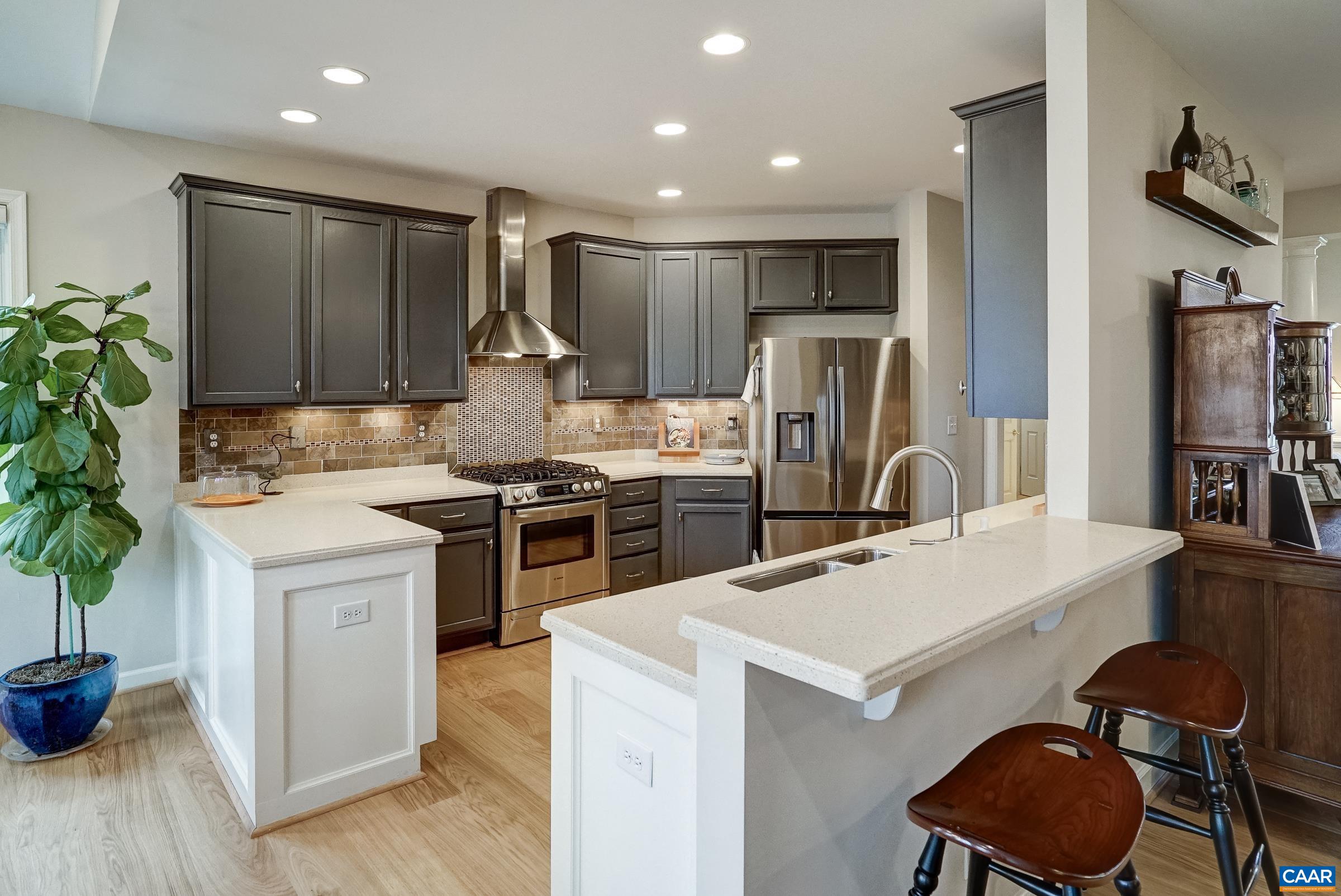 Great room opens to modern kitchen with breakfast bar seating.