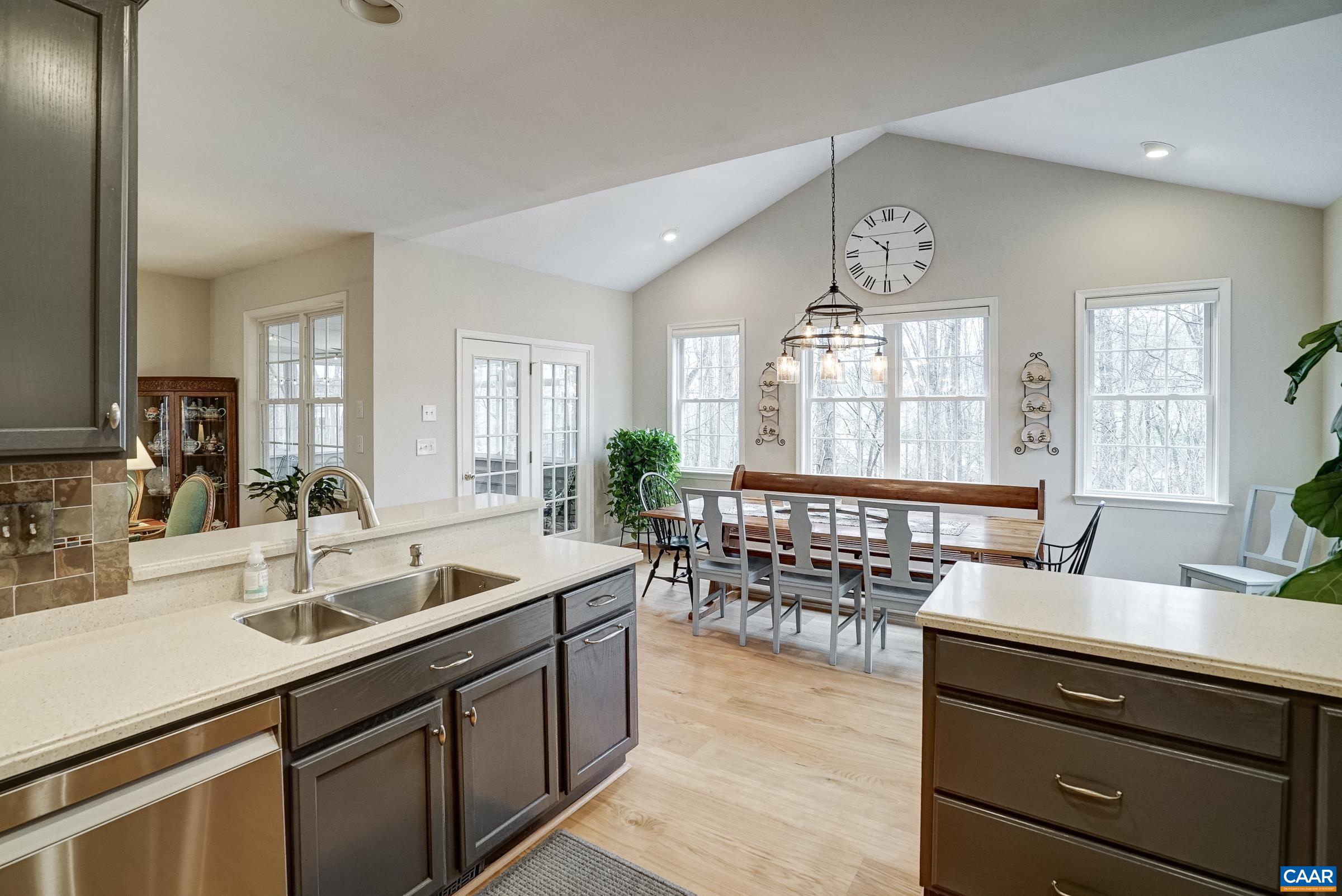 Kitchen opens to vaulted dining area with three sides of windows.