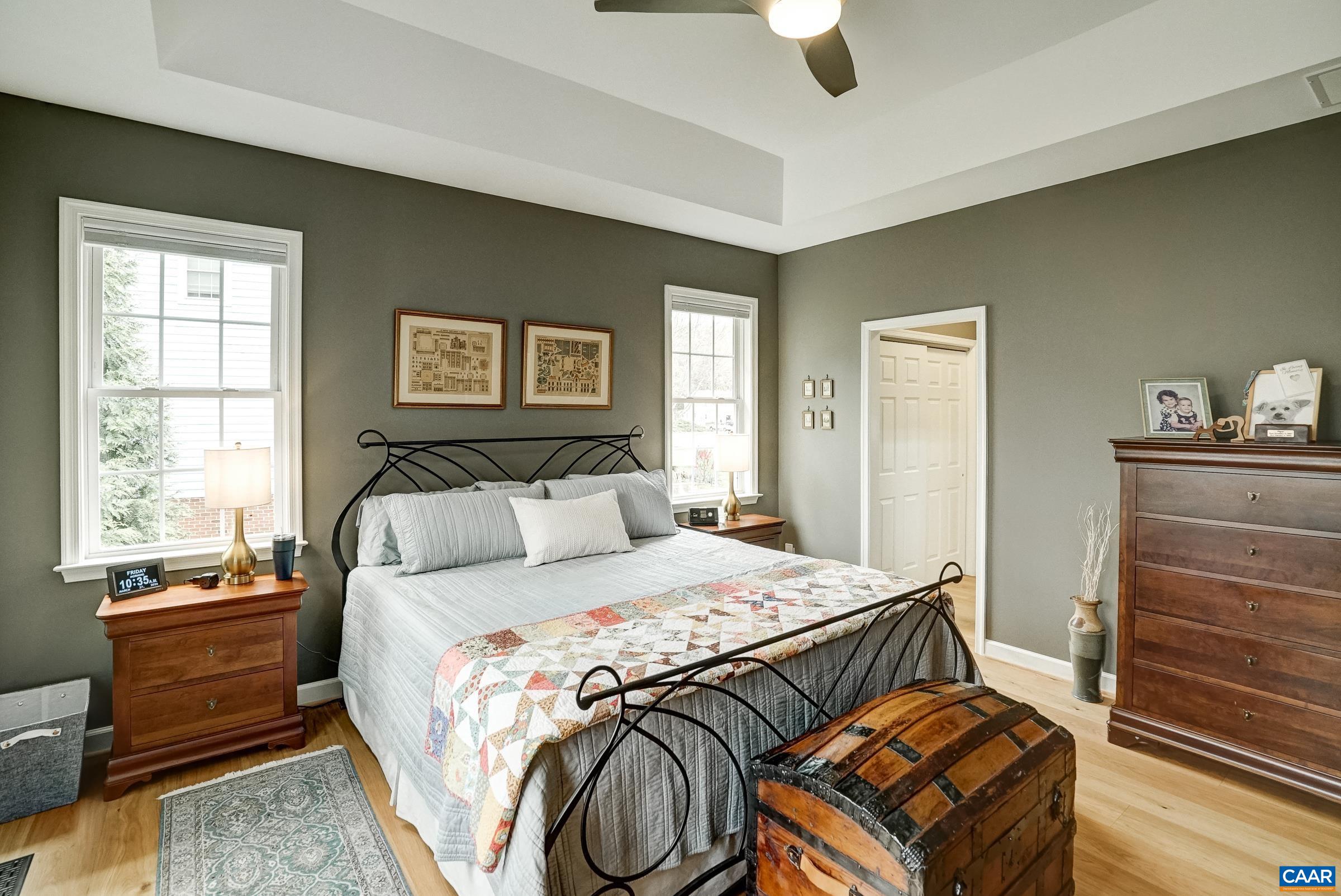 Ceiling fan and hardwood floors in the primary suite.
