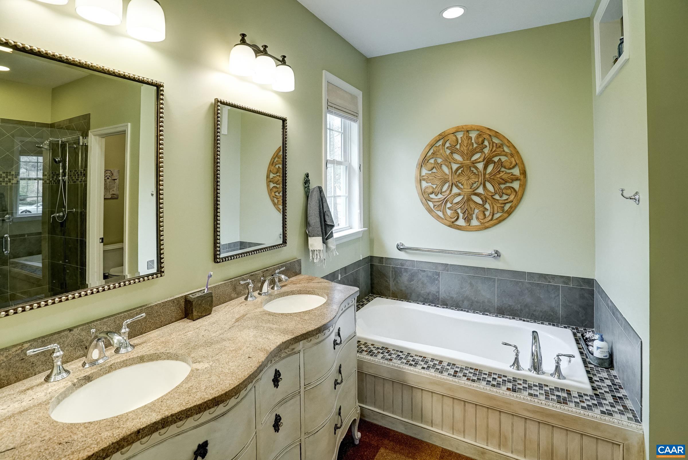 Ensuite bathroom with cork flooring. Relax in the soaking tub or separate shower with frameless glass door.  Handheld sprayer and grab bars for aging in place.
