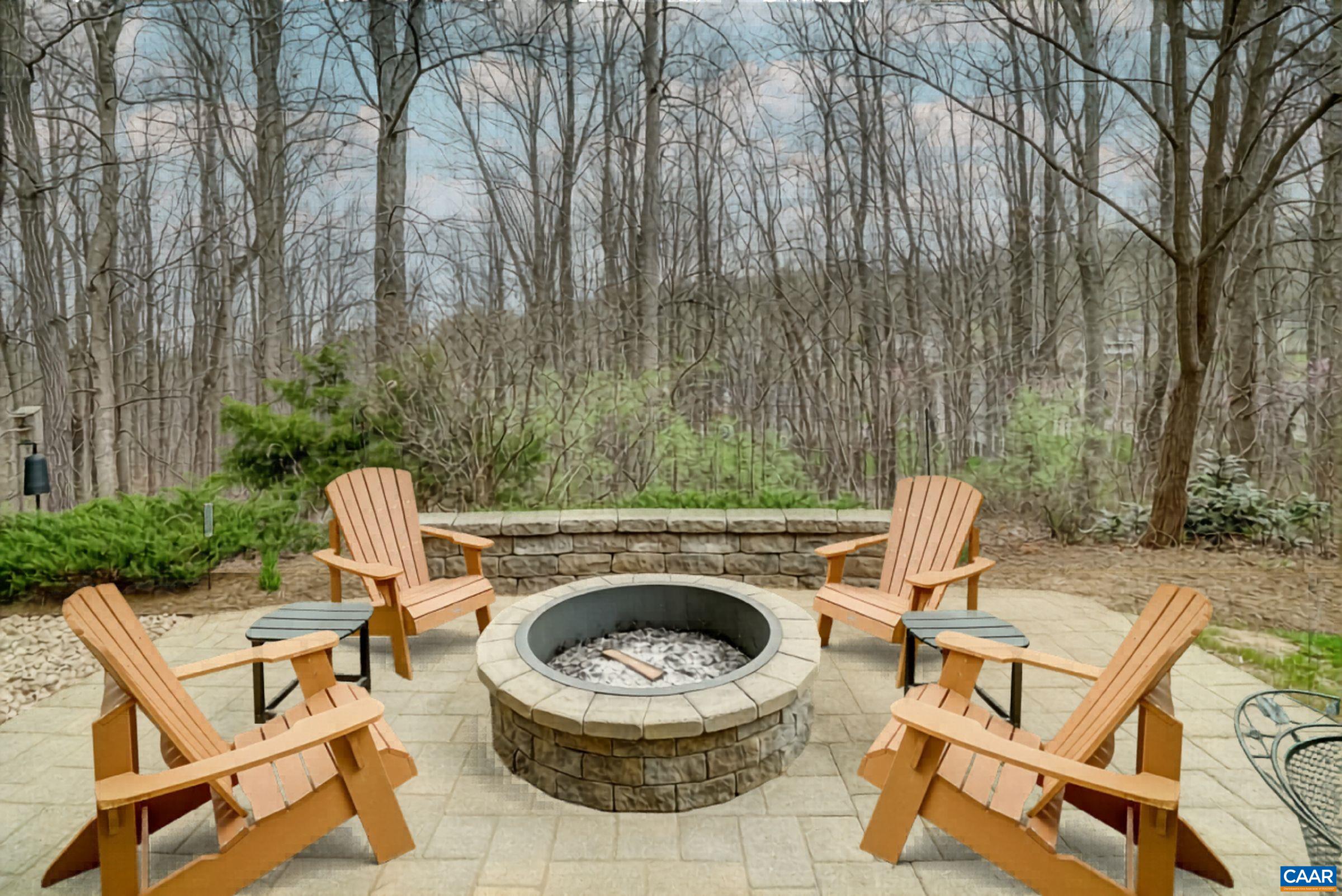 Private back yard with open space on two sides and mature screening plans on the third and paver patio with built-in firepit.