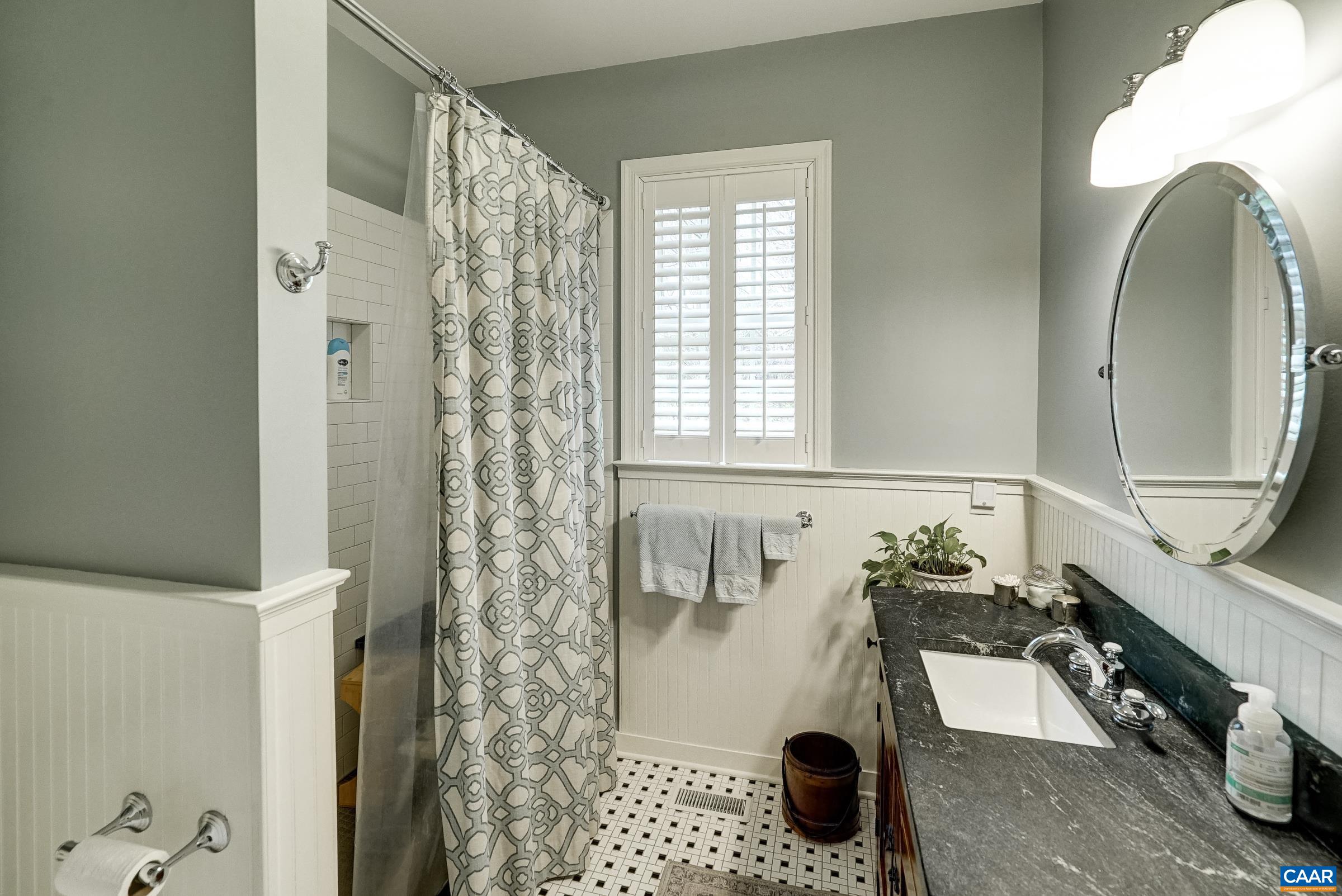 Main level full bathroom features a walk-in shower.