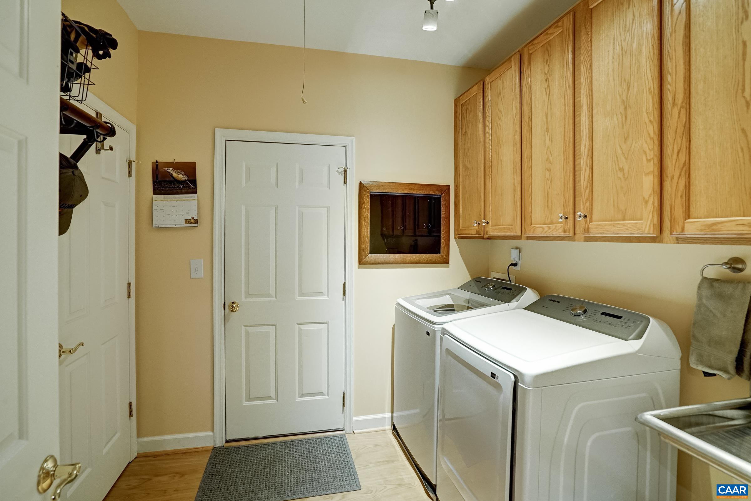 Large laundry/mudroom with utility sink, storage and washer/dryer.