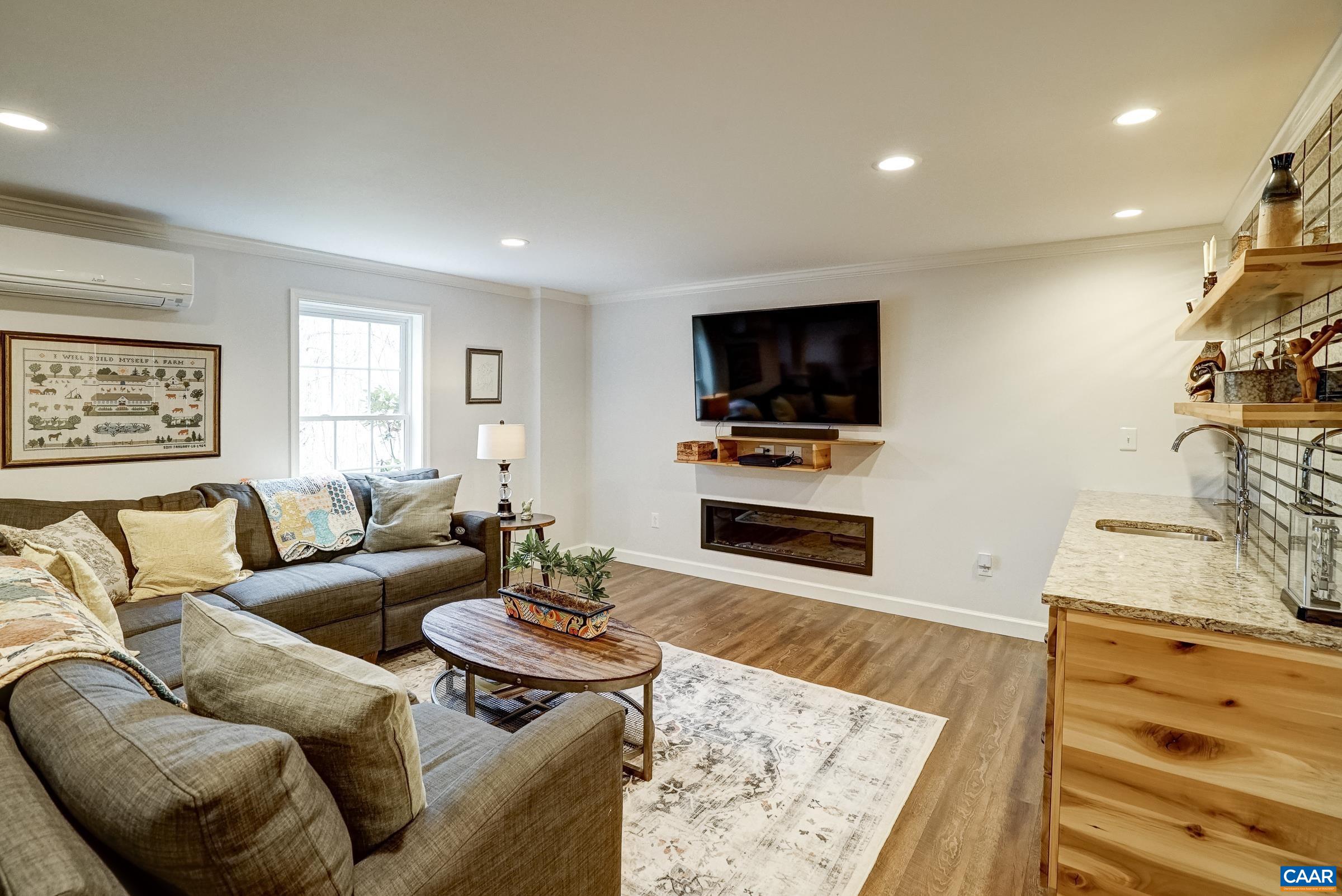 Finished walk-out terrace level features LVP flooring, mounted TV and electric fireplace.