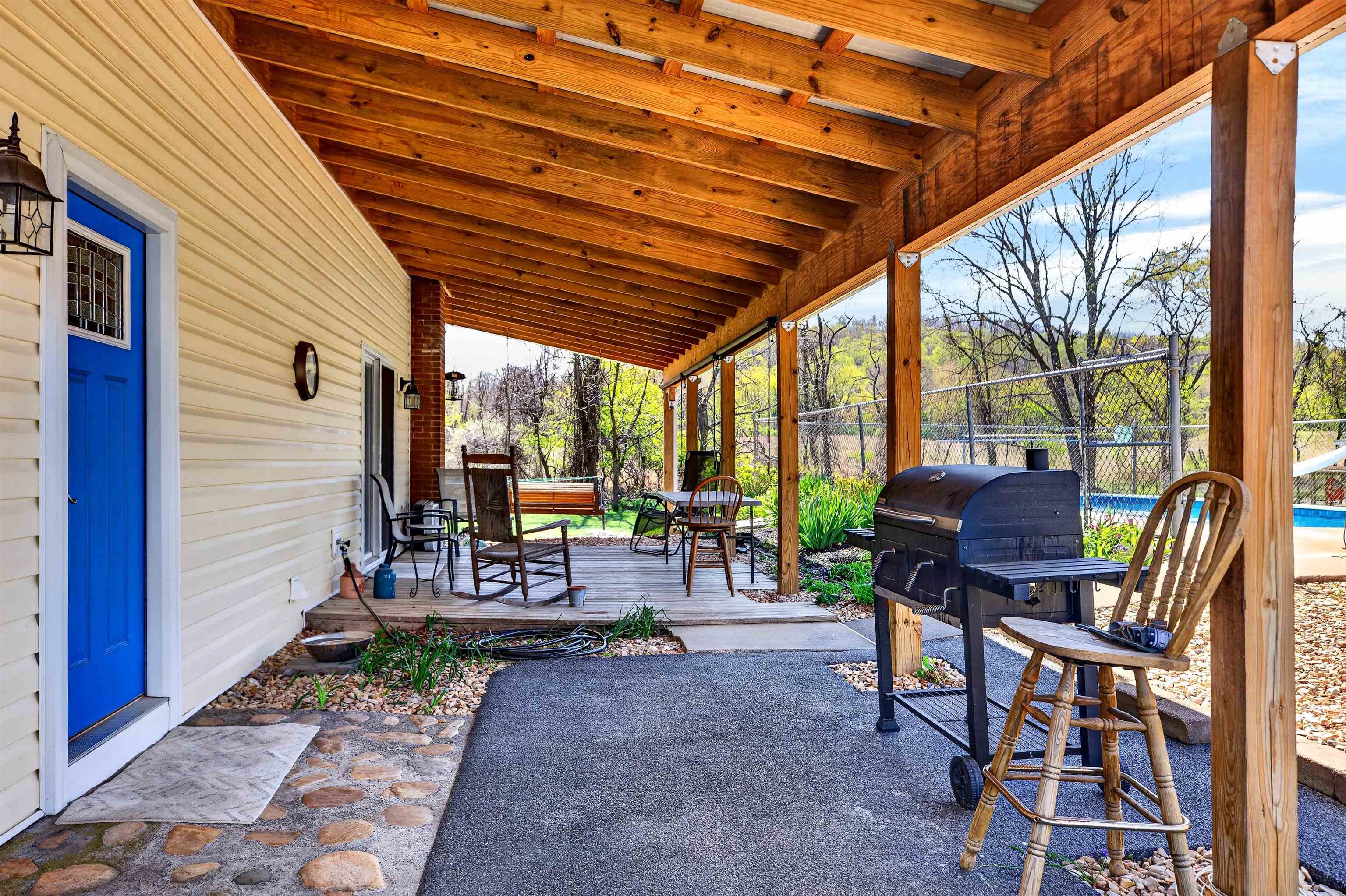 Main entry (blue door) opens into the eat-in kitchen, home office nook, and open living area. Covered patio offers a welcoming space to relax or entertain.