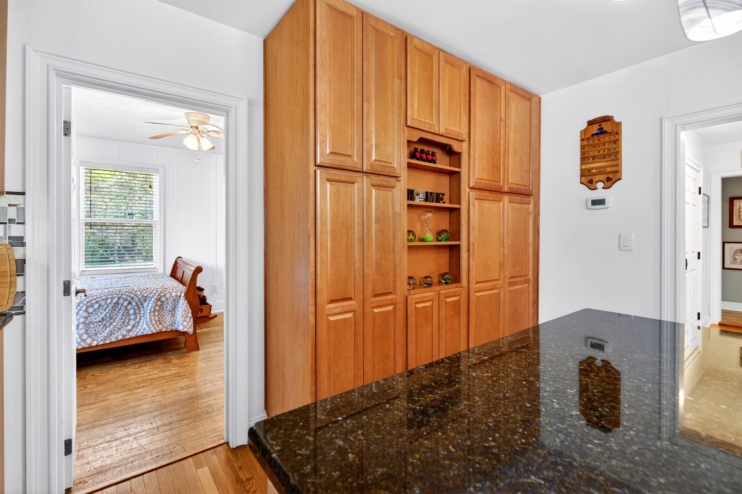 View from the kitchen into the secondary bedroom, offering flexible space for guests, office use, or additional living needs.