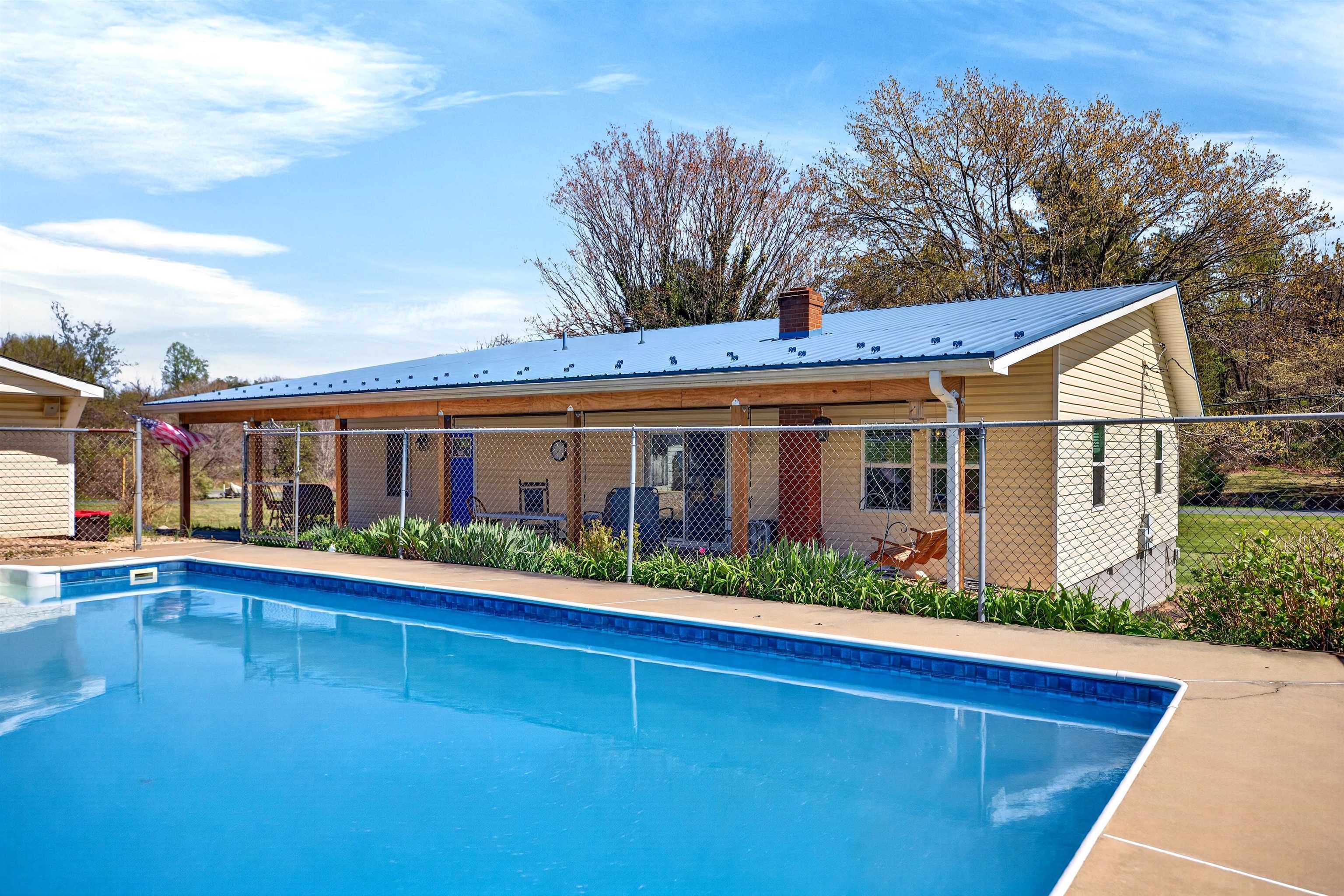 In-ground pool (approx. 5.5 ft depth) with surrounding patio and fencing — perfect for summer enjoyment, relaxing, and outdoor entertaining.