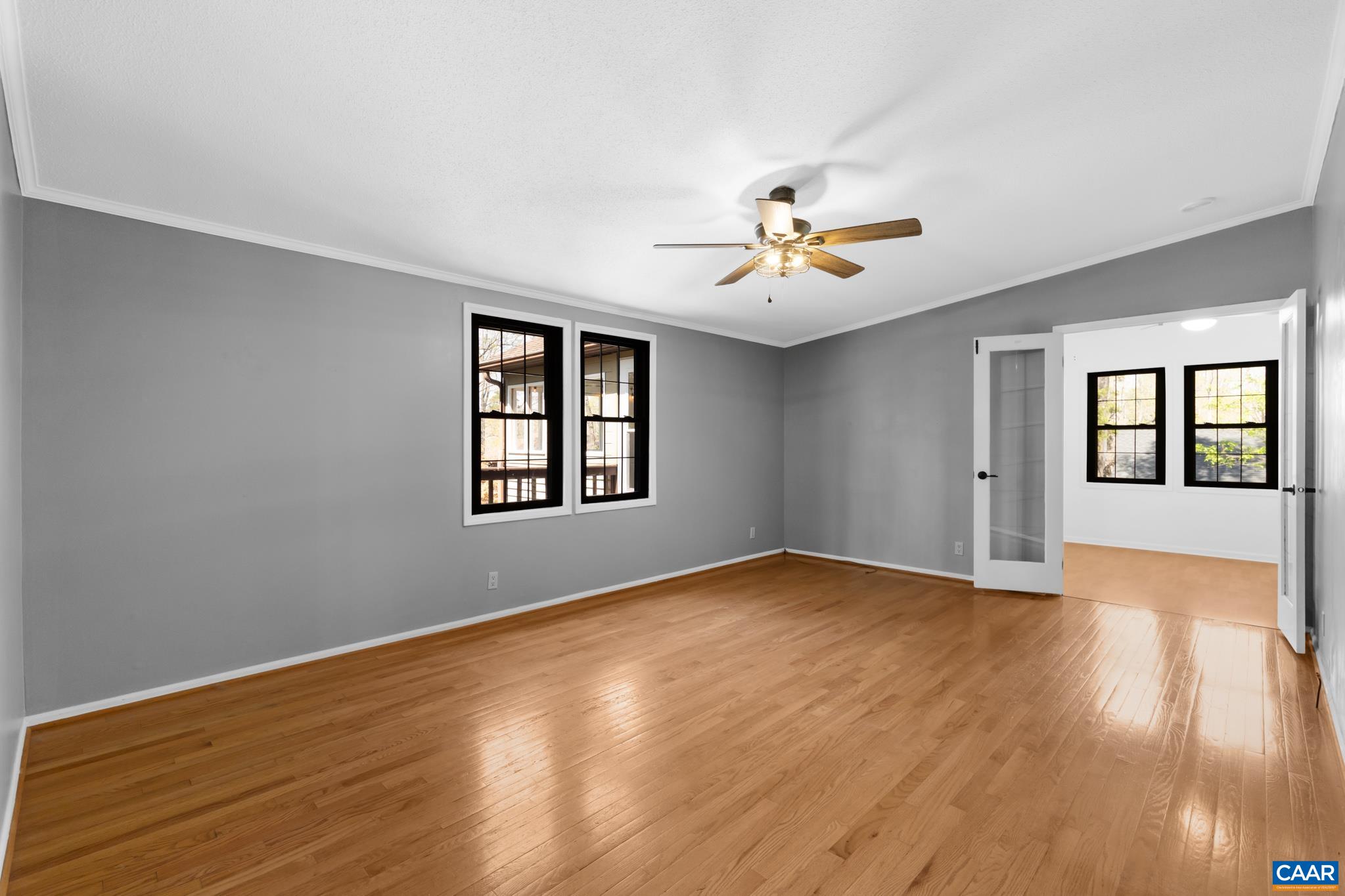 Bright, airy flex dining-family room with gleaming hardwood floors and large windows, perfect for a cozy retreat. Features a stylish ceiling fan and a glass French door leading to a home office. Bright, airy flex dining-family room with gleaming hardwood floors and large windows, perfect for a cozy retreat. Features a stylish ceiling fan and a glass French door leading to a home office.
