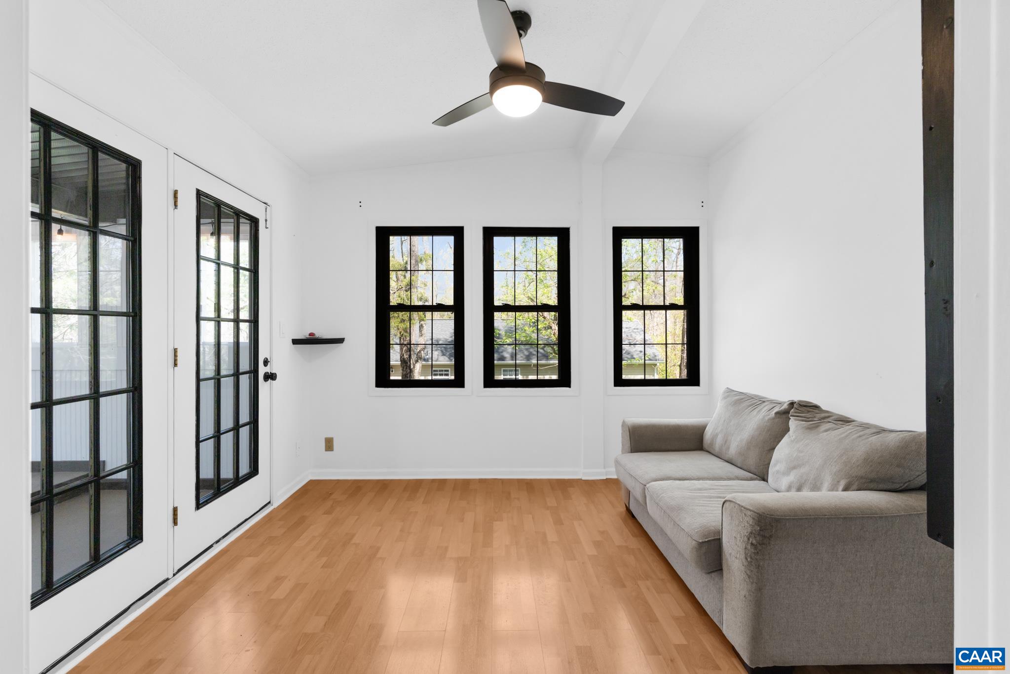 Enjoy a bright, airy office just off the sunroom with natural light and a modern ceiling fan. This versatile space features wood flooring, large windows with black frames, and double glass doors. Perfect for relaxing or entertaining! Enjoy a bright, airy office just off the sunroom with natural light and a modern ceiling fan. This versatile space features wood flooring, large windows with black frames, and double glass doors. Perfect for relaxing or entertaining!