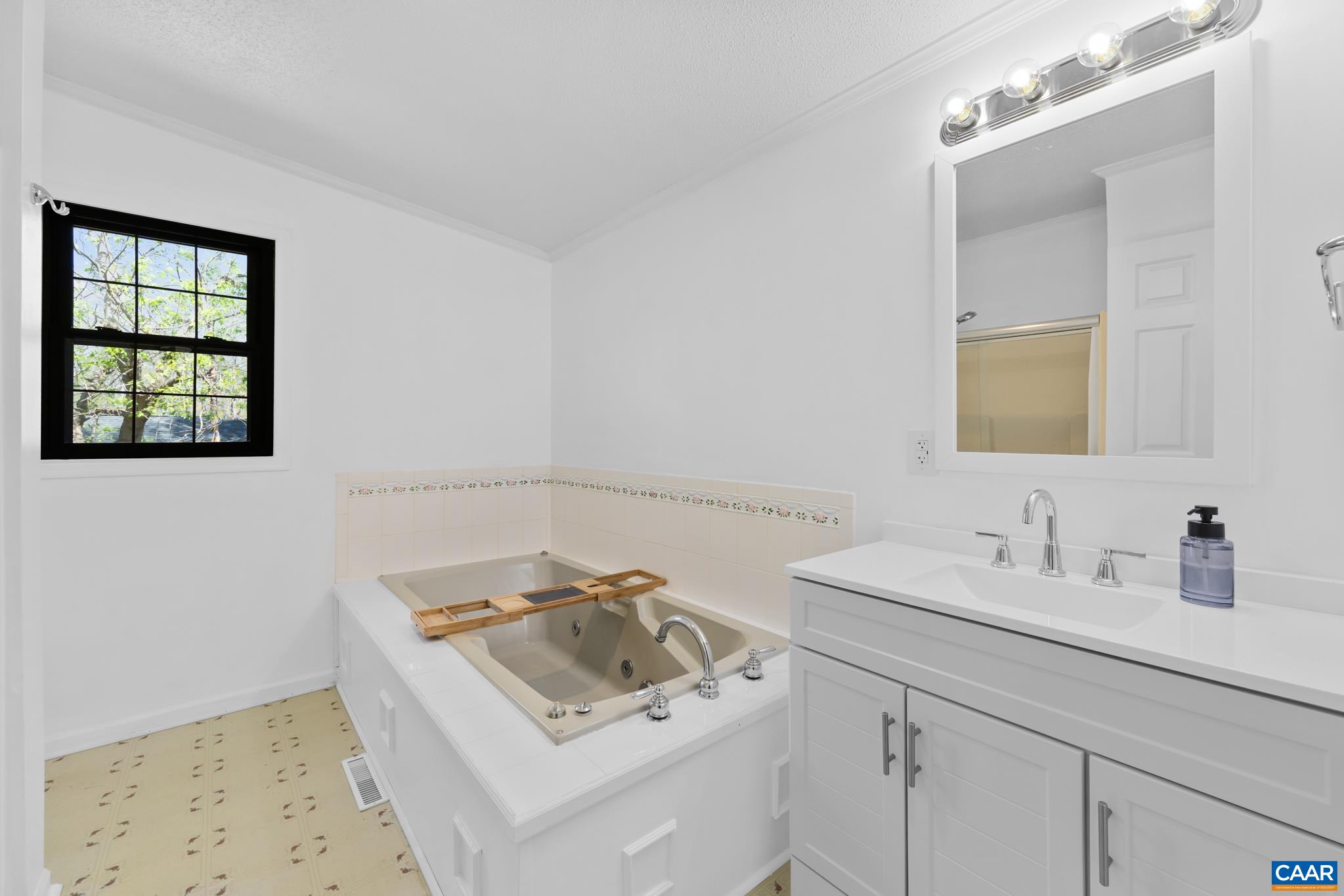 Relax and unwind in this primary bathroom featuring a luxurious jetted tub, perfect for a soothing soak after a long day. The bright, spacious design and ample counter space complete the spa-like experience. Relax and unwind in this primary bathroom featuring a luxurious jetted tub, perfect for a soothing soak after a long day. The bright, spacious design and ample counter space complete the spa-like experience.