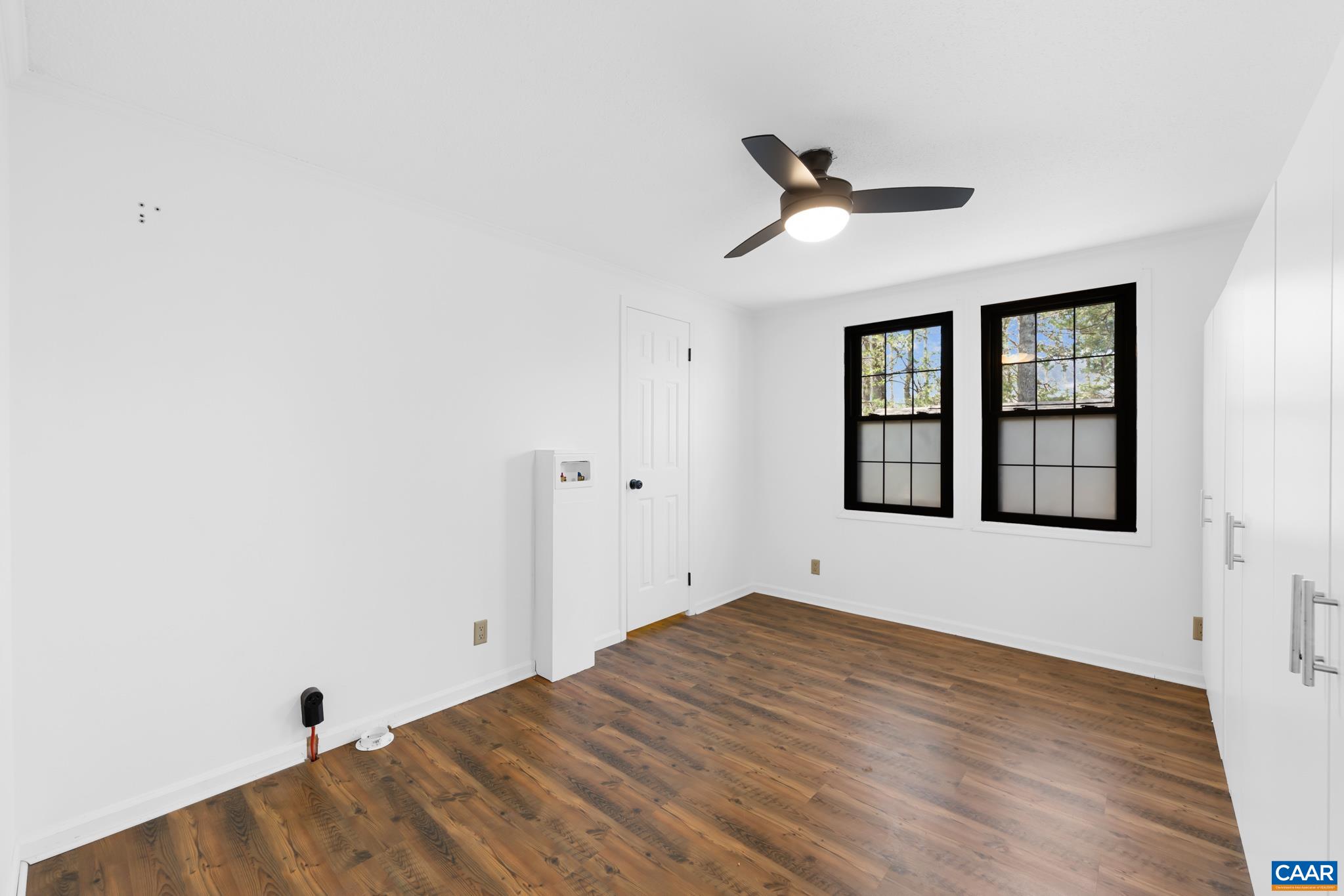 Flexible living in this bright room! Use it as a bedroom with ample closet space or as a convenient laundry room/flex space, featuring wood-look floors and modern black-trim windows. Flexible living in this bright room! Use it as a bedroom with ample closet space or as a convenient laundry room/flex space, featuring wood-look floors and modern black-trim windows.