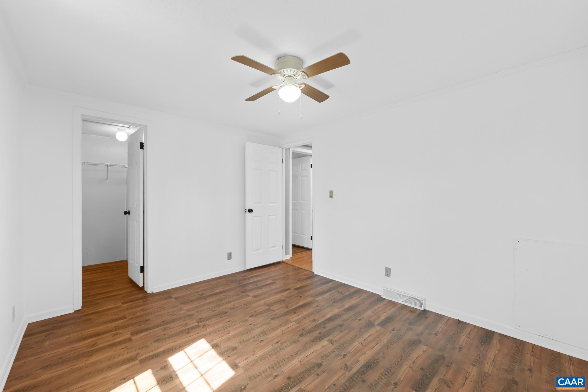 Spacious and bright 3rd bedroom featuring durable wood-look flooring, a stylish ceiling fan/light, and convenient access to a large walk-in closet. The crisp white walls are ready for your personal touch! Spacious and bright 3rd bedroom featuring durable wood-look flooring, a stylish ceiling fan/light, and convenient access to a large walk-in closet. The crisp white walls are ready for your personal touch!