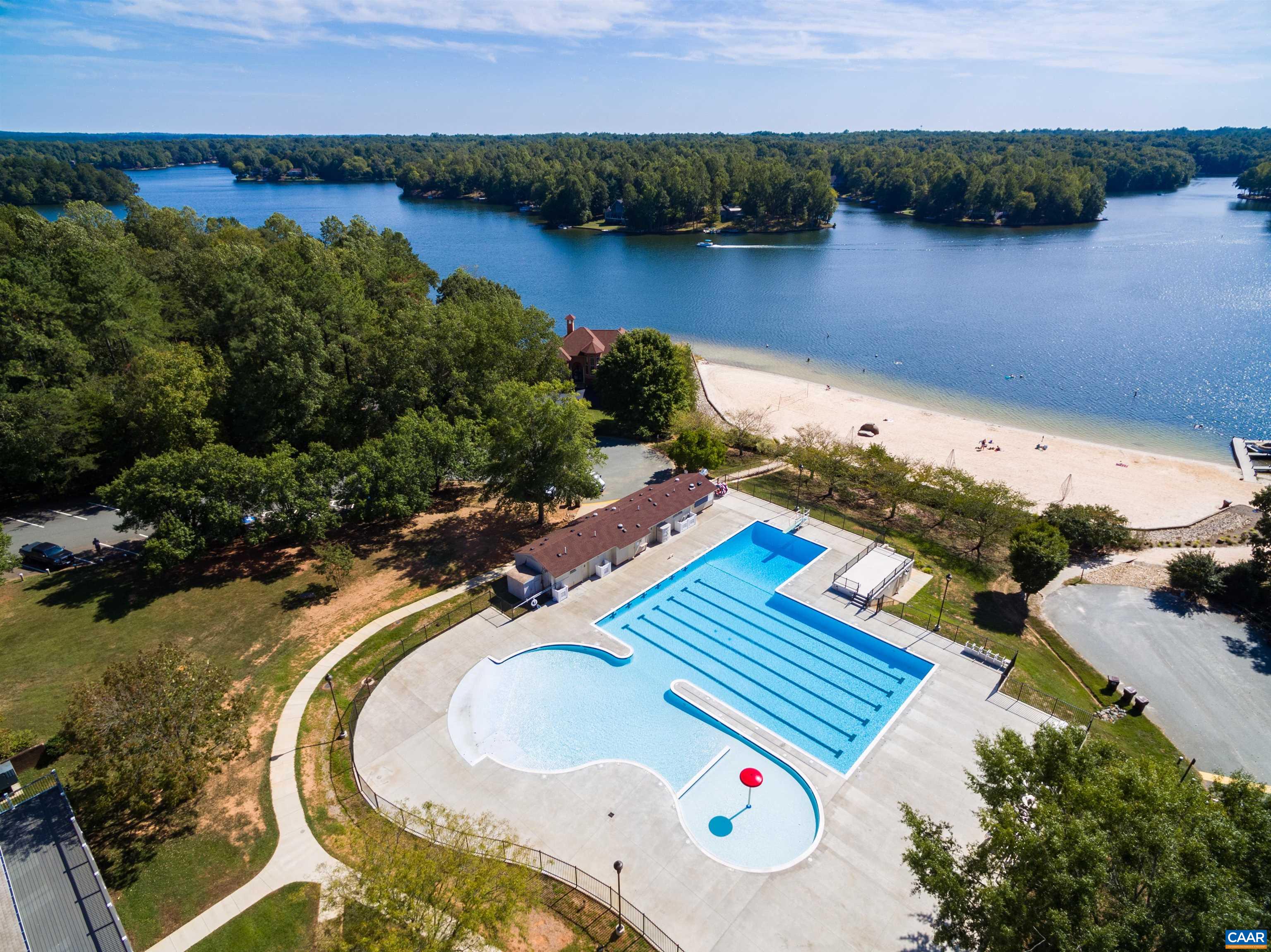 Dive into summer fun! This stunning lakefront park features a pool with lap lanes and a fun section, plus a sandy beach for sunbathing. Enjoy the water and surrounding lush trees. Dive into summer fun! This stunning lakefront park features a pool with lap lanes and a fun section, plus a sandy beach for sunbathing. Enjoy the water and surrounding lush trees.