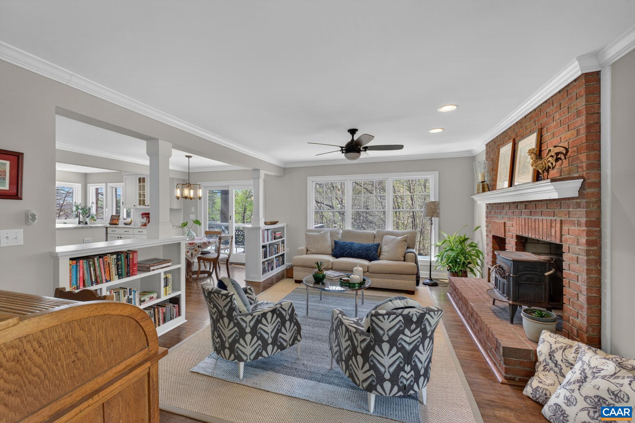 and breakfast nook. Wonderful space to gather, separated by half wall/bookshelves and with raised hearth brick fireplace/wood-stove