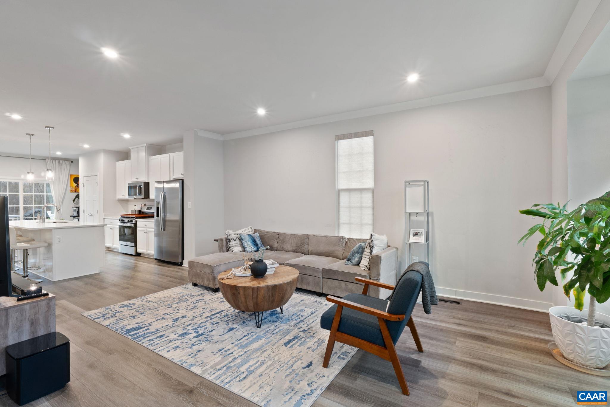 Spacious living room with abundant natural light, modern flooring, and open sightlines to the kitchen. Spacious living room with abundant natural light, modern flooring, and open sightlines to the kitchen.