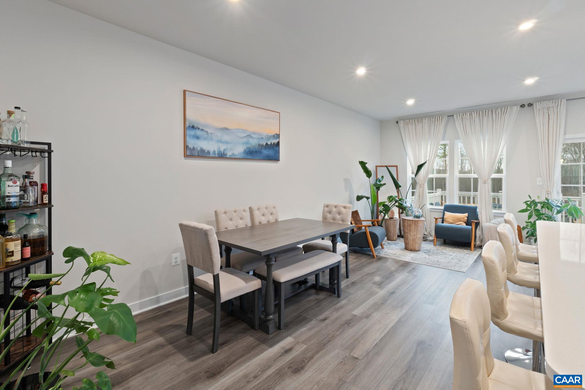 Open dining area with modern flooring, recessed lighting, and seamless flow to the living space, perfect for everyday meals and entertaining. Open dining area with modern flooring, recessed lighting, and seamless flow to the living space, perfect for everyday meals and entertaining.