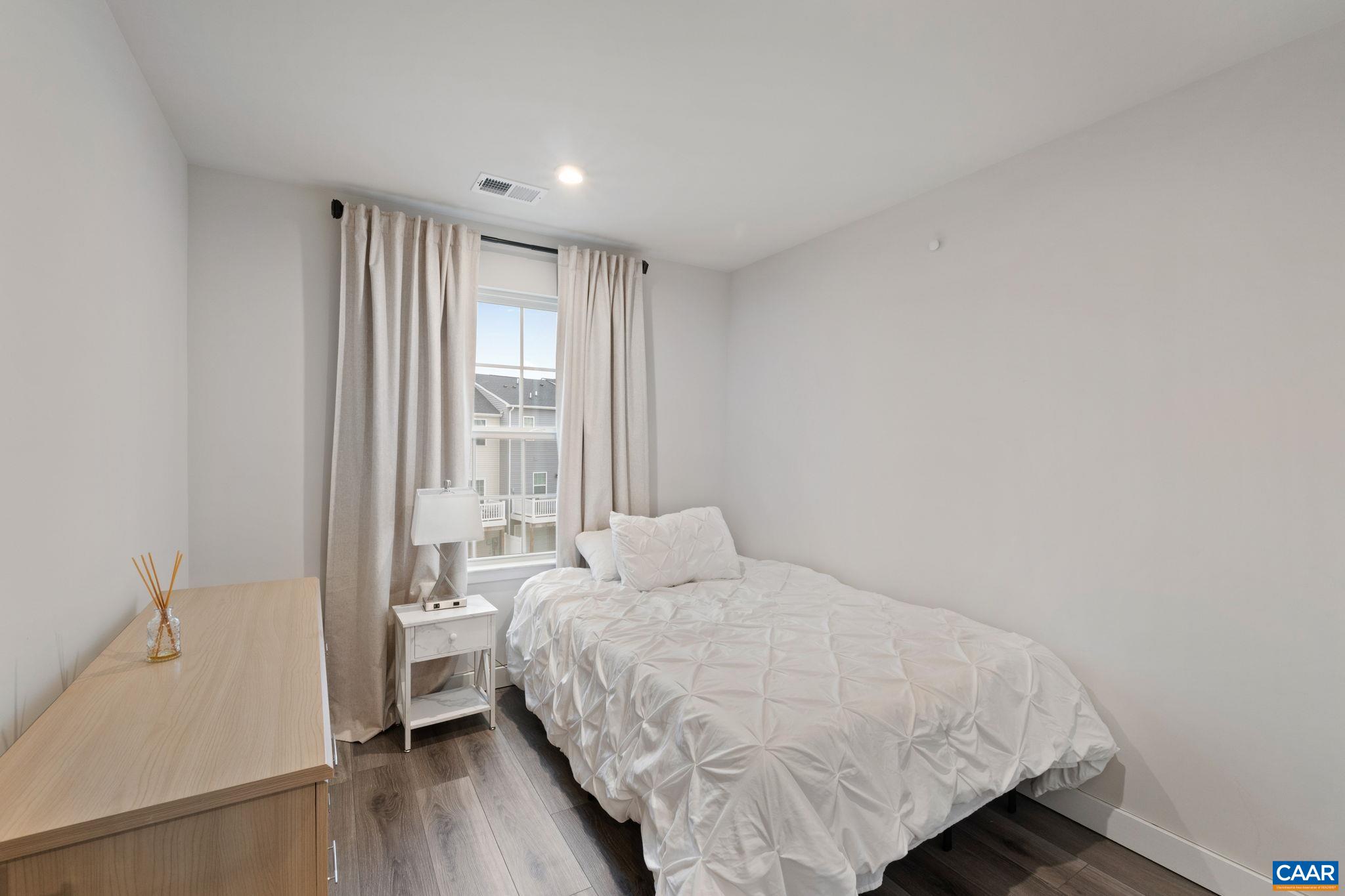 Cozy bedroom featuring a large window for natural light, neutral tones, and a functional layout—ideal as a guest room, office, or flex space. Cozy bedroom featuring a large window for natural light, neutral tones, and a functional layout—ideal as a guest room, office, or flex space.