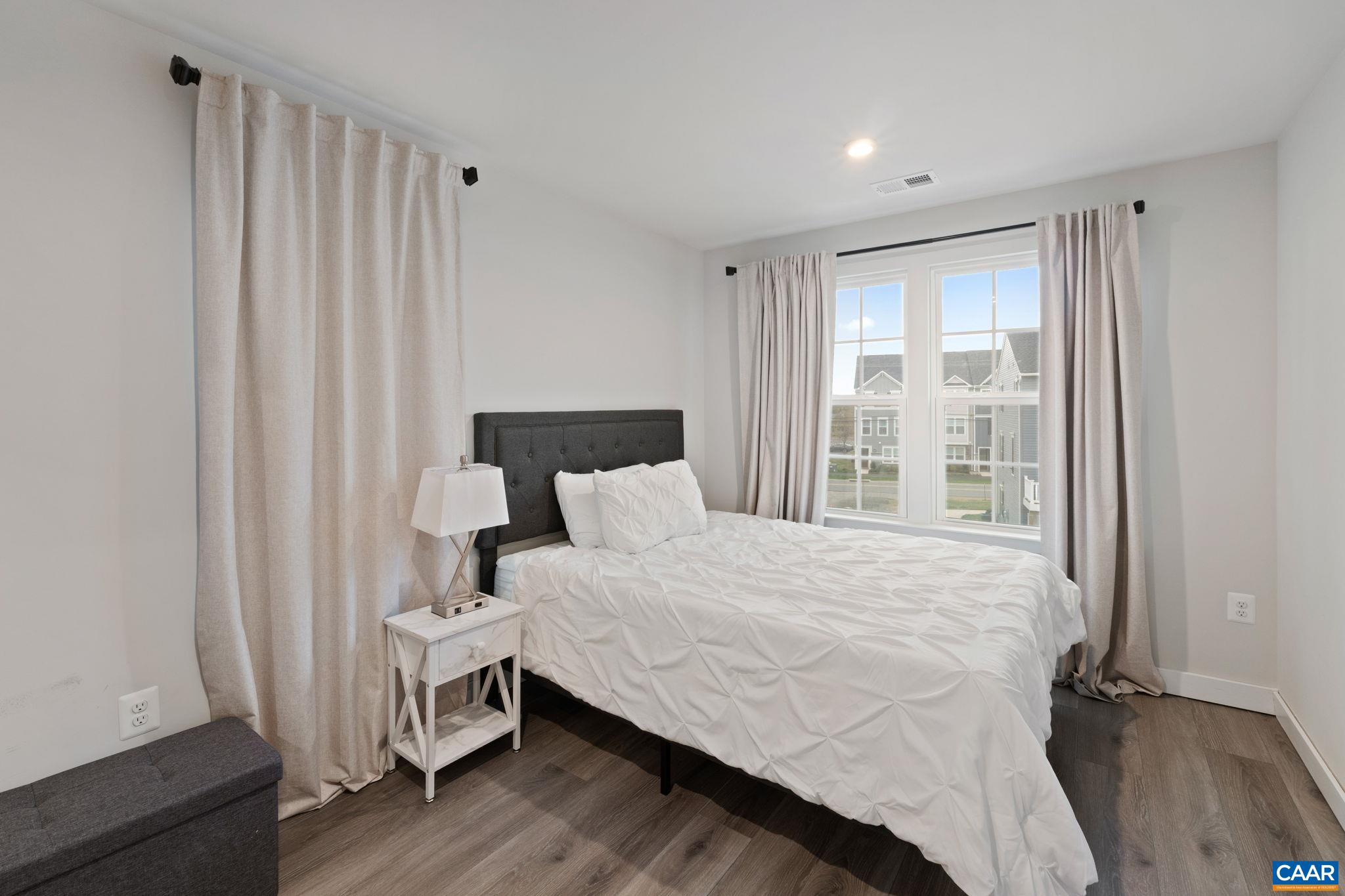 Comfortable third-floor bedroom featuring ample natural light, neutral finishes, and a functional layout—ideal for guests, family, or a home office. Comfortable third-floor bedroom featuring ample natural light, neutral finishes, and a functional layout—ideal for guests, family, or a home office.