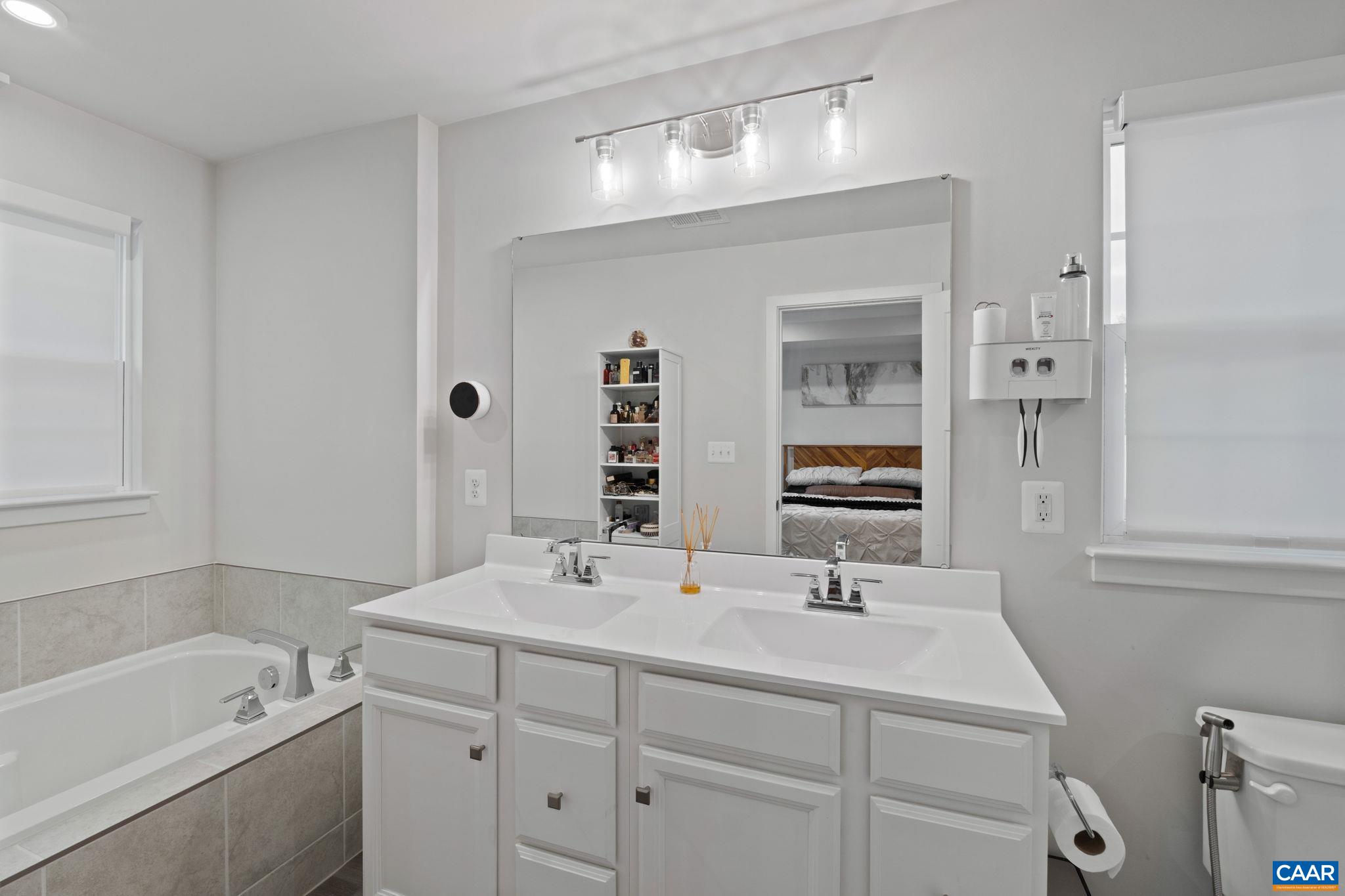 Alternate view of the primary bath highlighting double vanity layout, modern fixtures, and a bright, clean design with both tub and walk-in shower. Alternate view of the primary bath highlighting double vanity layout, modern fixtures, and a bright, clean design with both tub and walk-in shower.
