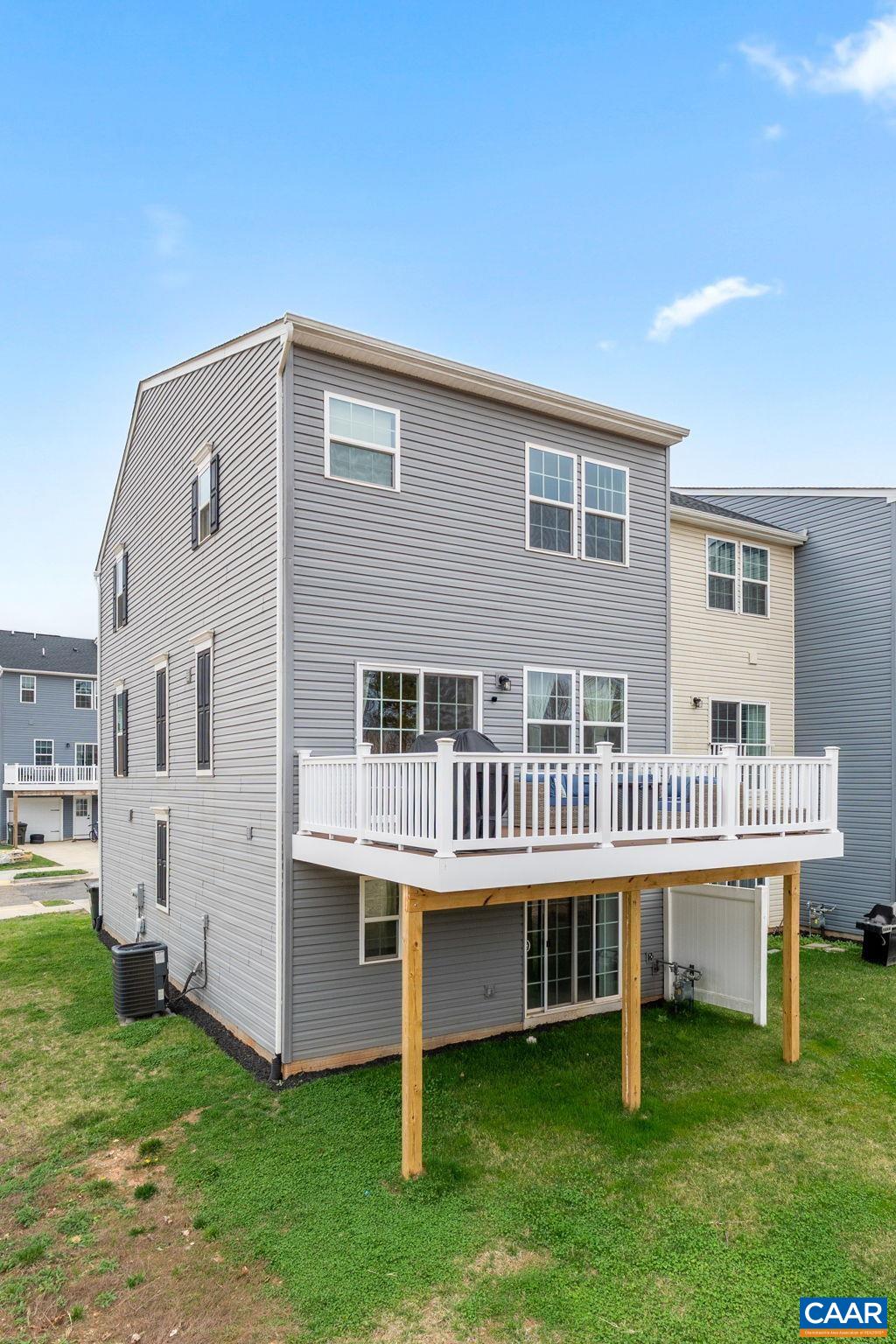 Spacious rear deck overlooking a private backyard, perfect for outdoor entertaining or relaxing. Elevated design provides added privacy with access to lower-level patio area. Low-maintenance exterior with vinyl siding. Spacious rear deck overlooking a private backyard, perfect for outdoor entertaining or relaxing. Elevated design provides added privacy with access to lower-level patio area. Low-maintenance exterior with vinyl siding.