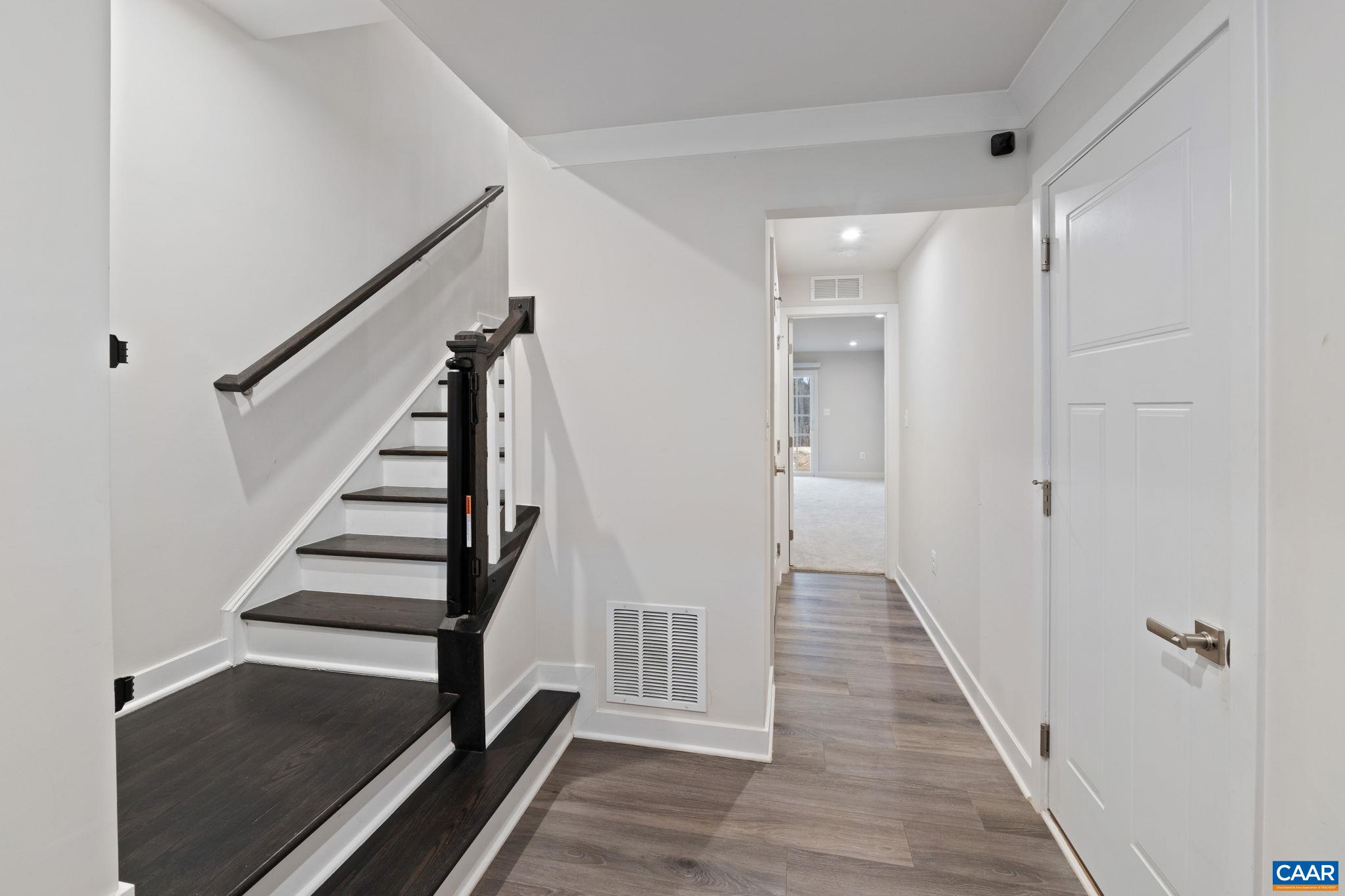 Entry-level foyer with modern flooring, staircase to main living area, and access to additional living space. Clean, open layout with contemporary finishes. Entry-level foyer with modern flooring, staircase to main living area, and access to additional living space. Clean, open layout with contemporary finishes.