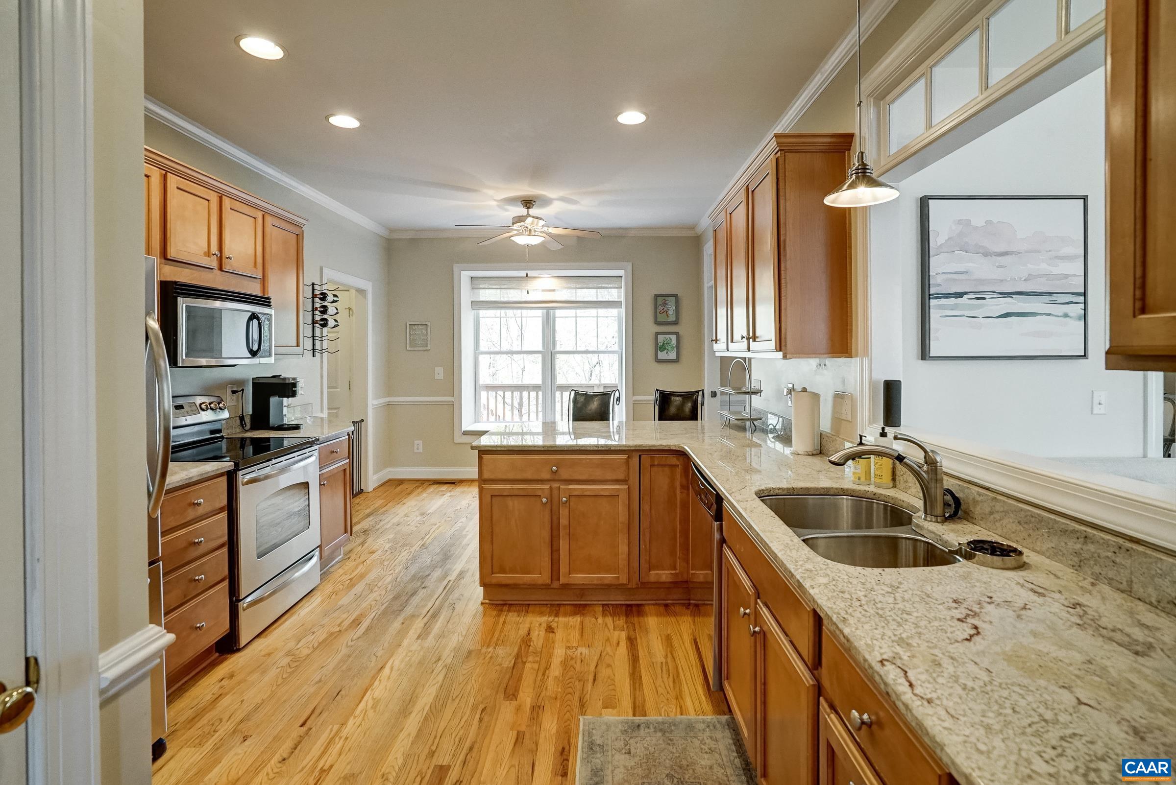 Open kitchen features granite counters and maple cabinets.