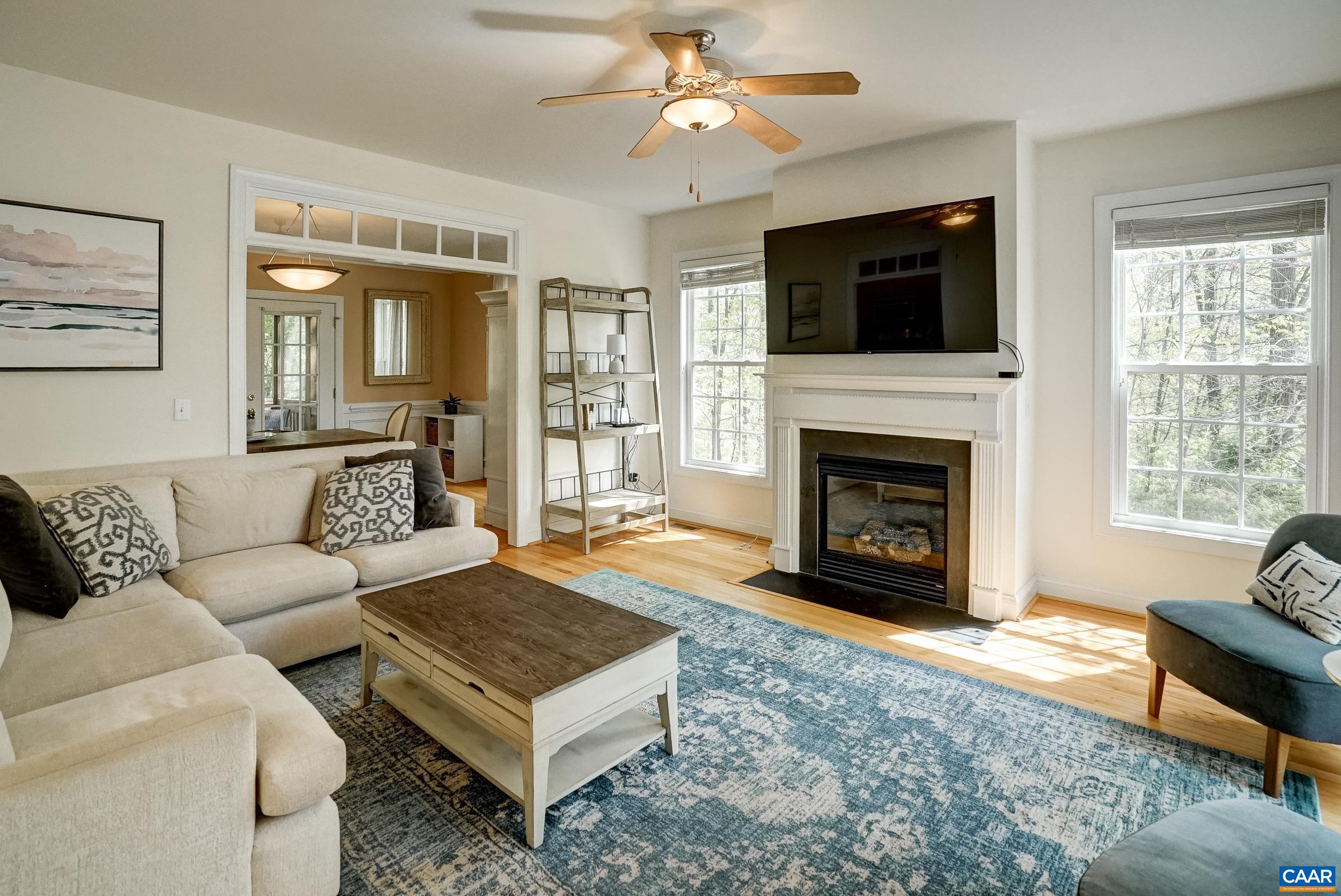 Gas fireplace and ceiling fan in living room.