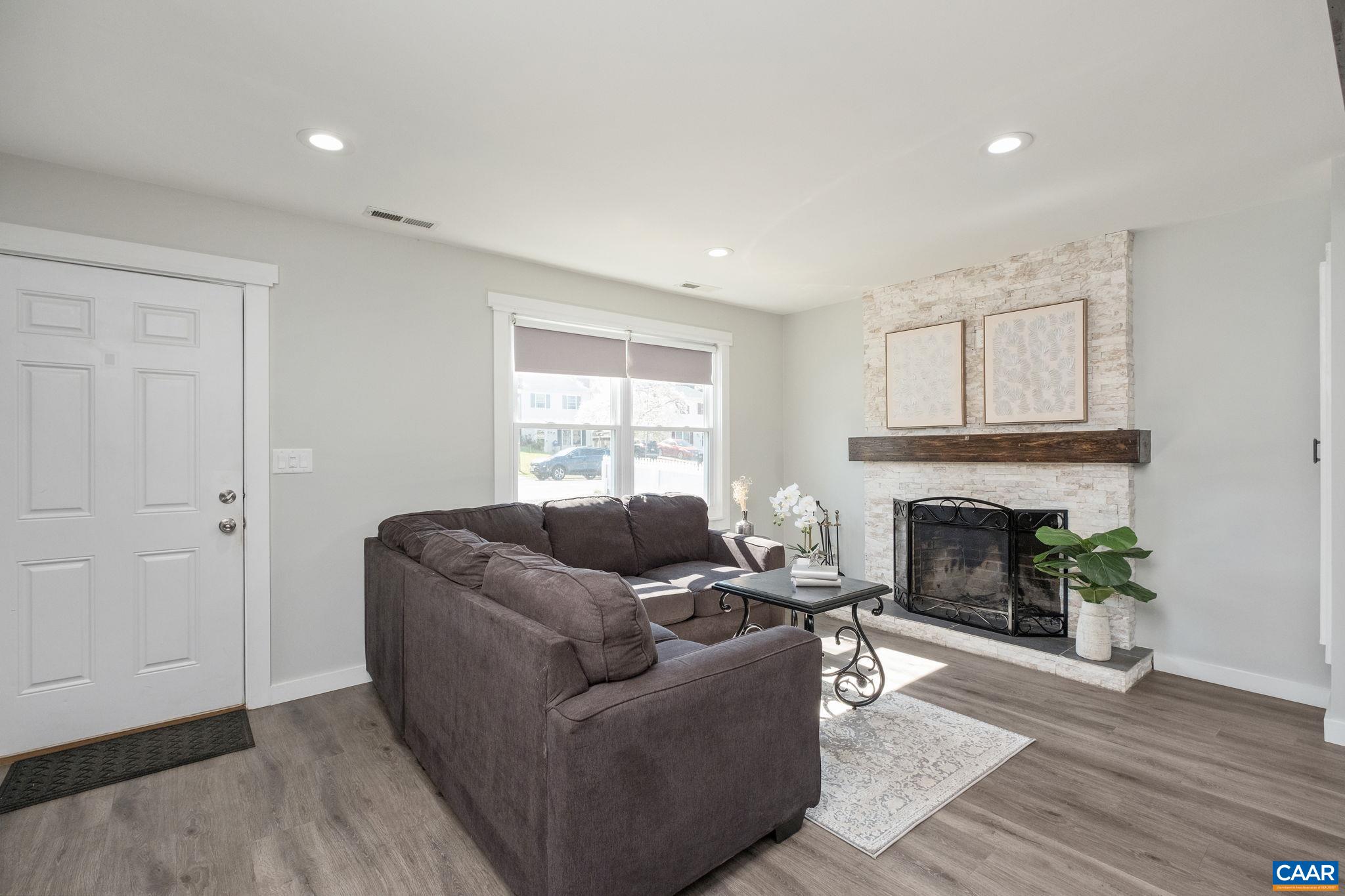 Open living room with stone fireplace.