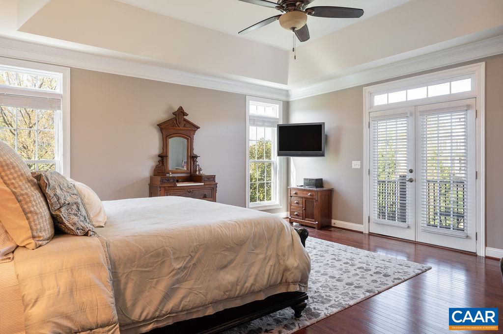 Primary Bedroom has a tray ceiling and ceiling fan