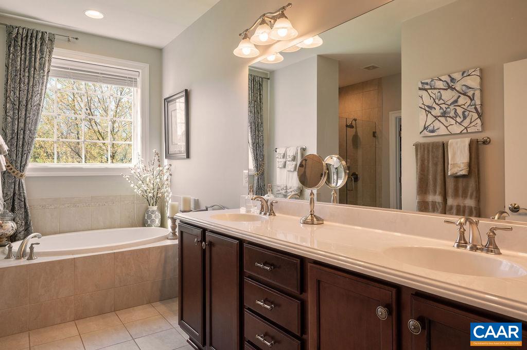 Luxurious primary bath has double vanities and a soaking tub...