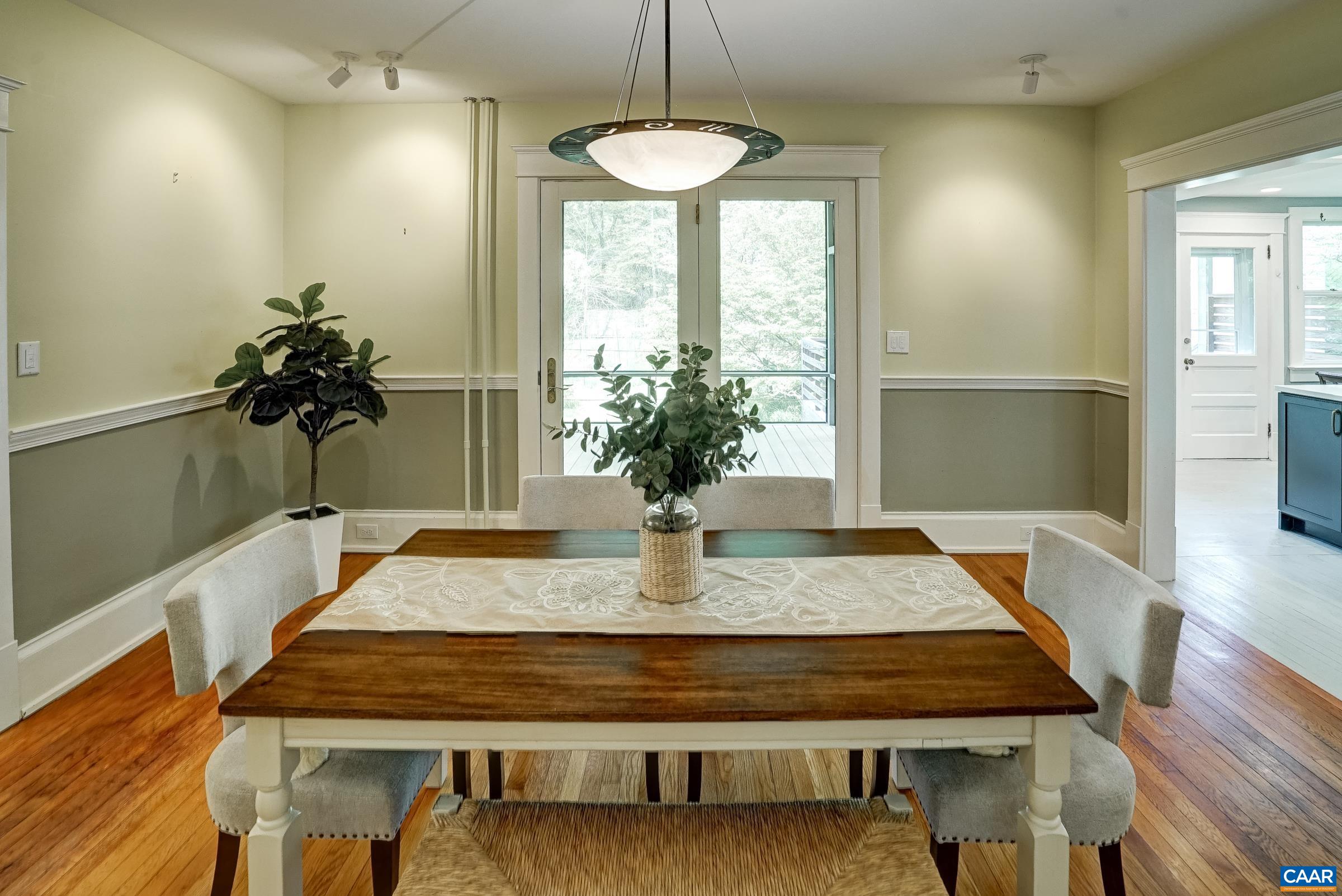 Large dining room with floor to ceiling french doors leading to screened porch.