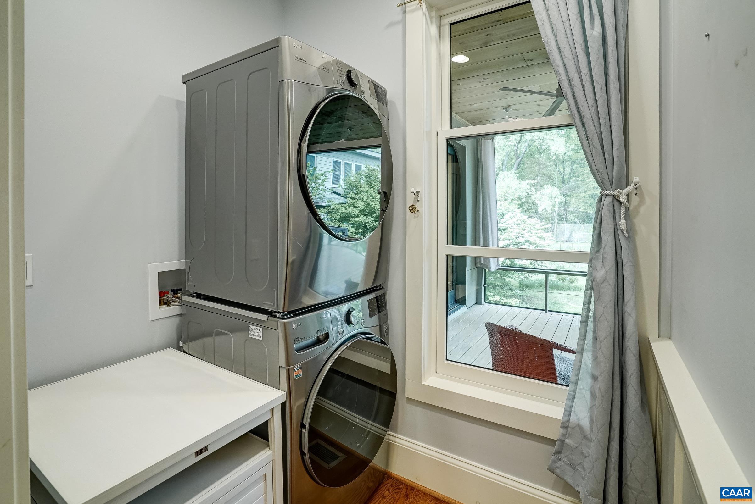 Laundry with stacked washer and dryer.